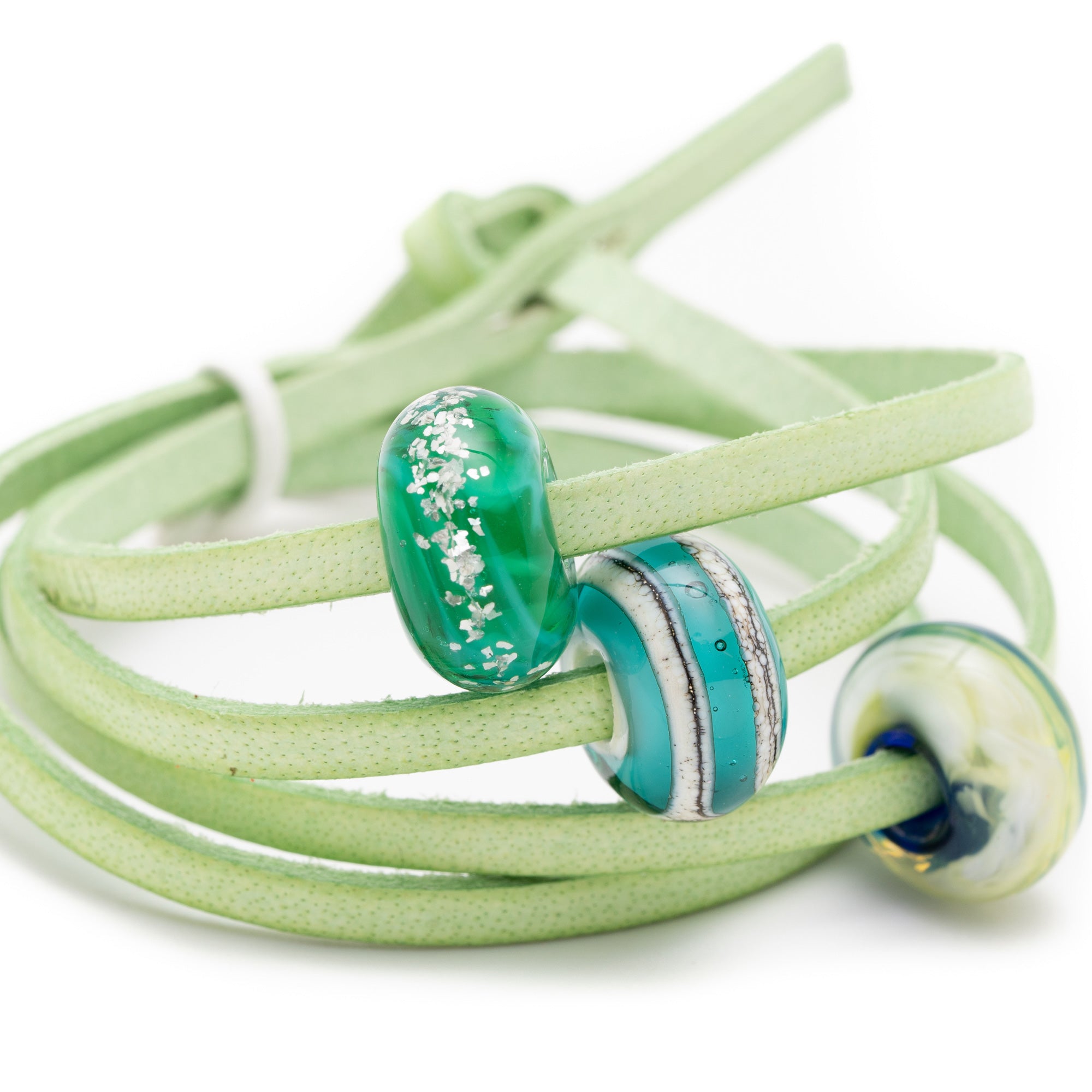 Green shiny glass beads on mint green leather wrap bracelet.