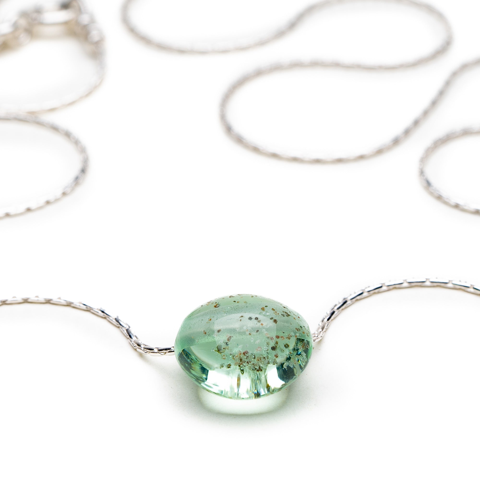 Sea glass green glass pebbel with beach sand melted in on silver chain necklace.