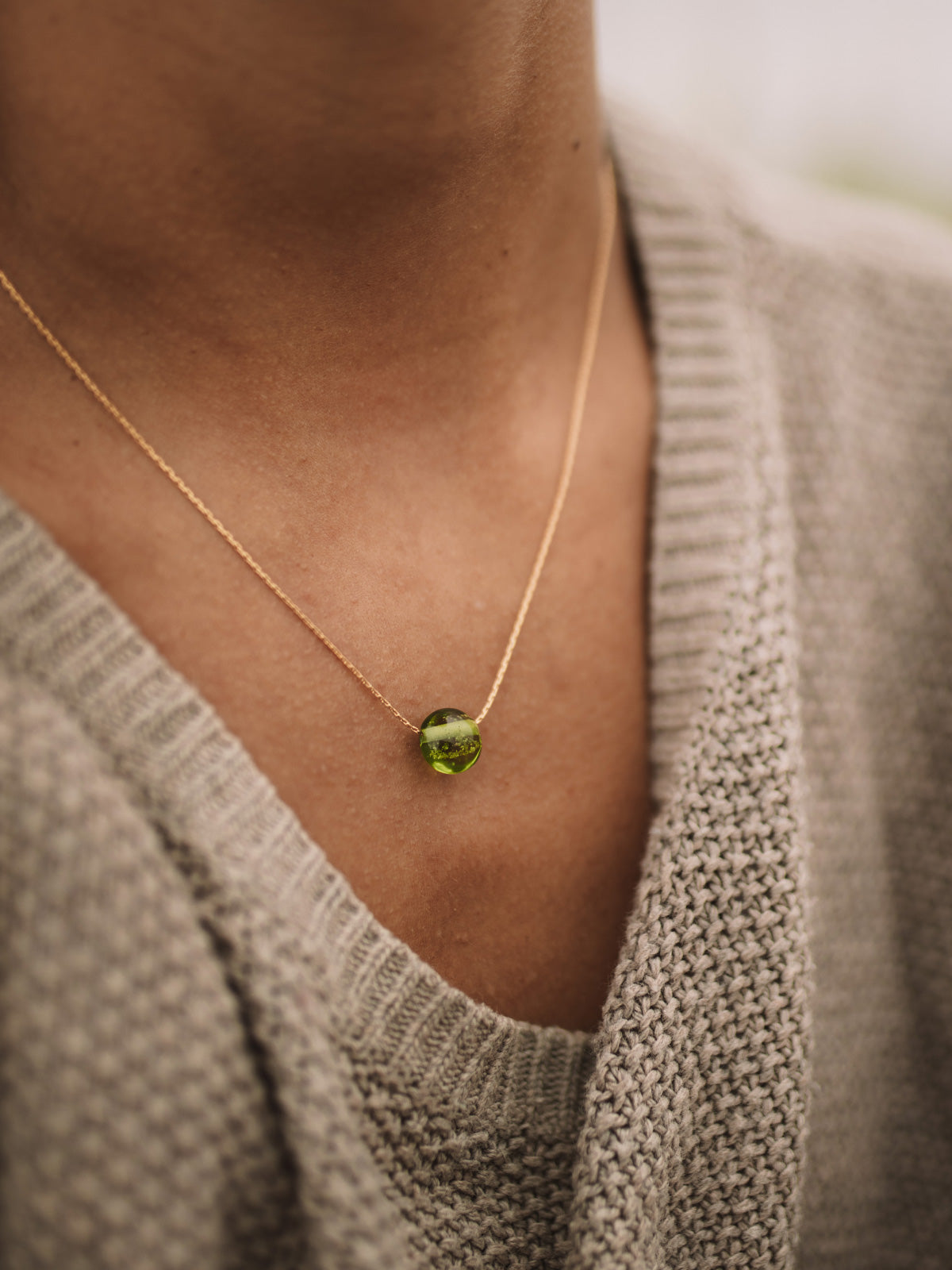 Green glass pebble necklace on fine gold chain.
