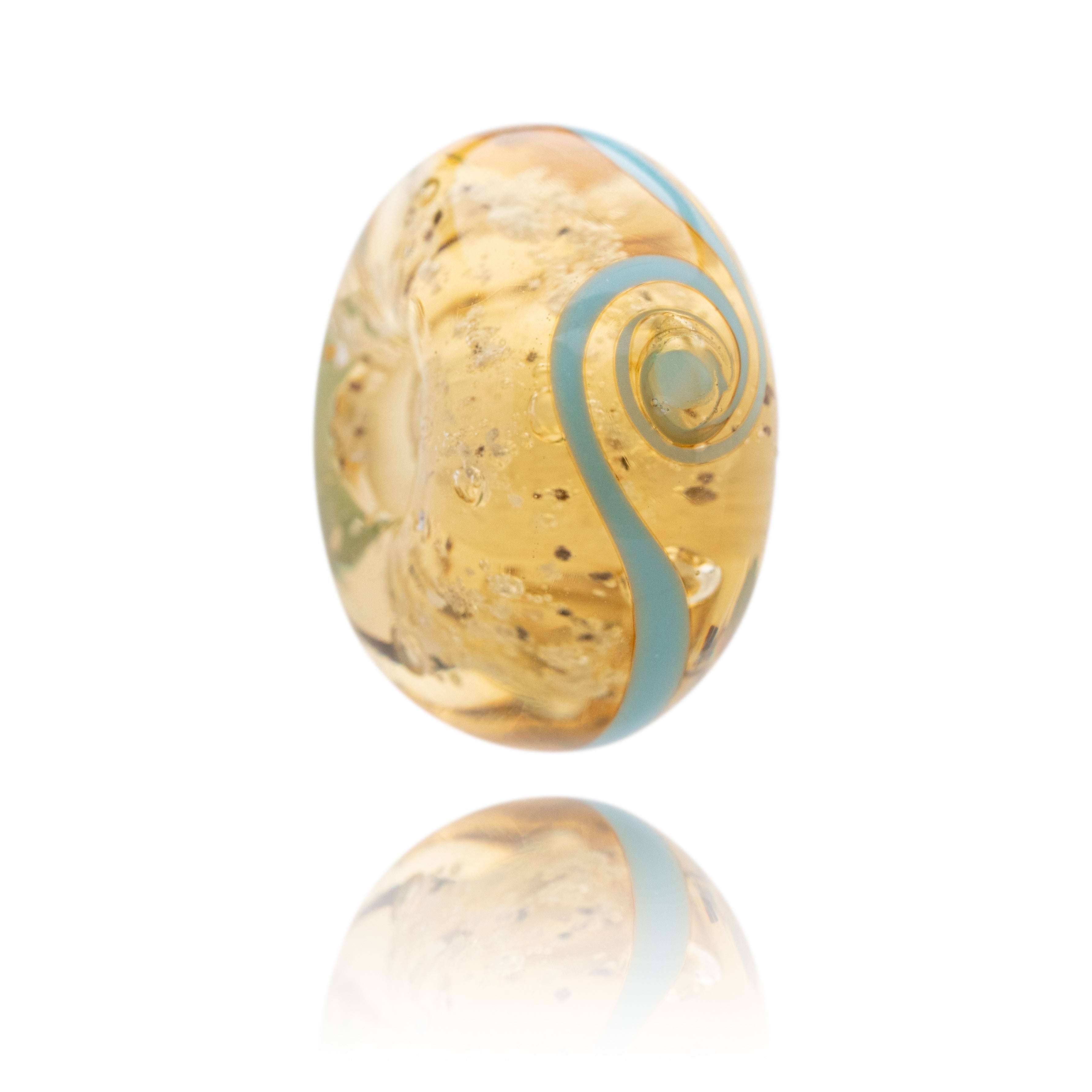 Glass bead with gold and blue swirl pattern on a white background