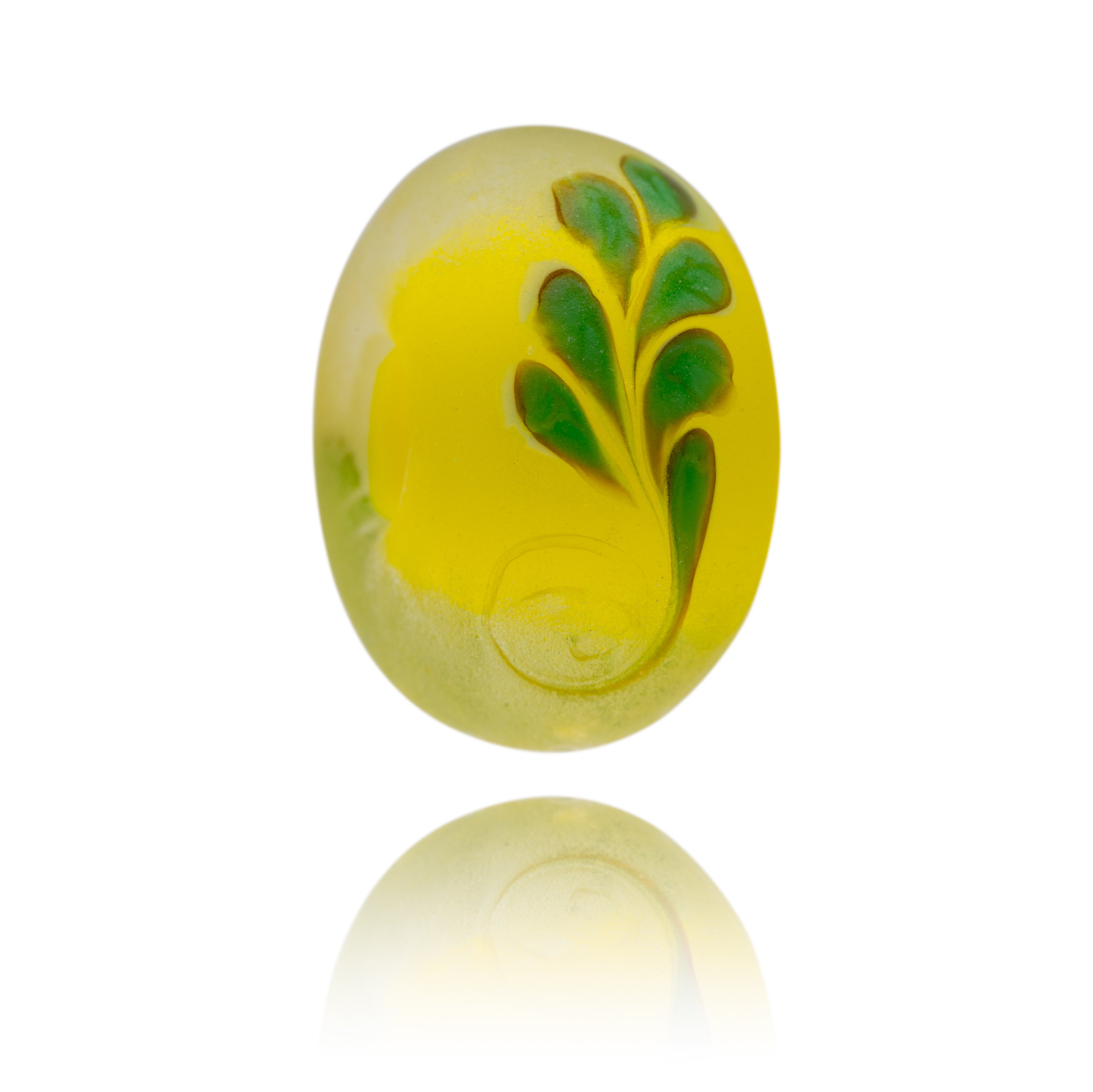 Yellow glass bead with green frond patter on surface. Representing Brazil in South America.