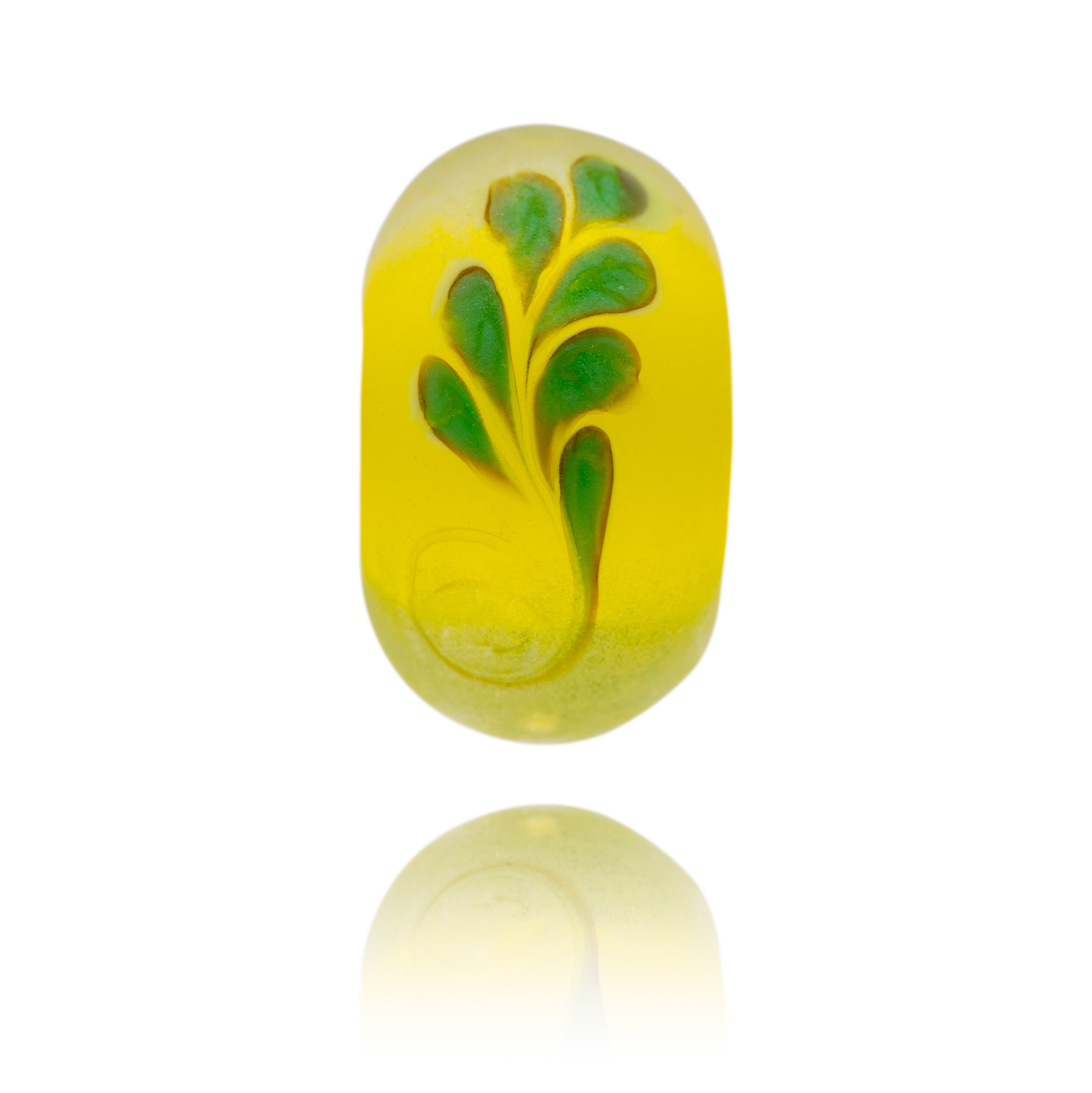 Yellow glass bead with green frond patter on surface. Representing Brazil in South America.