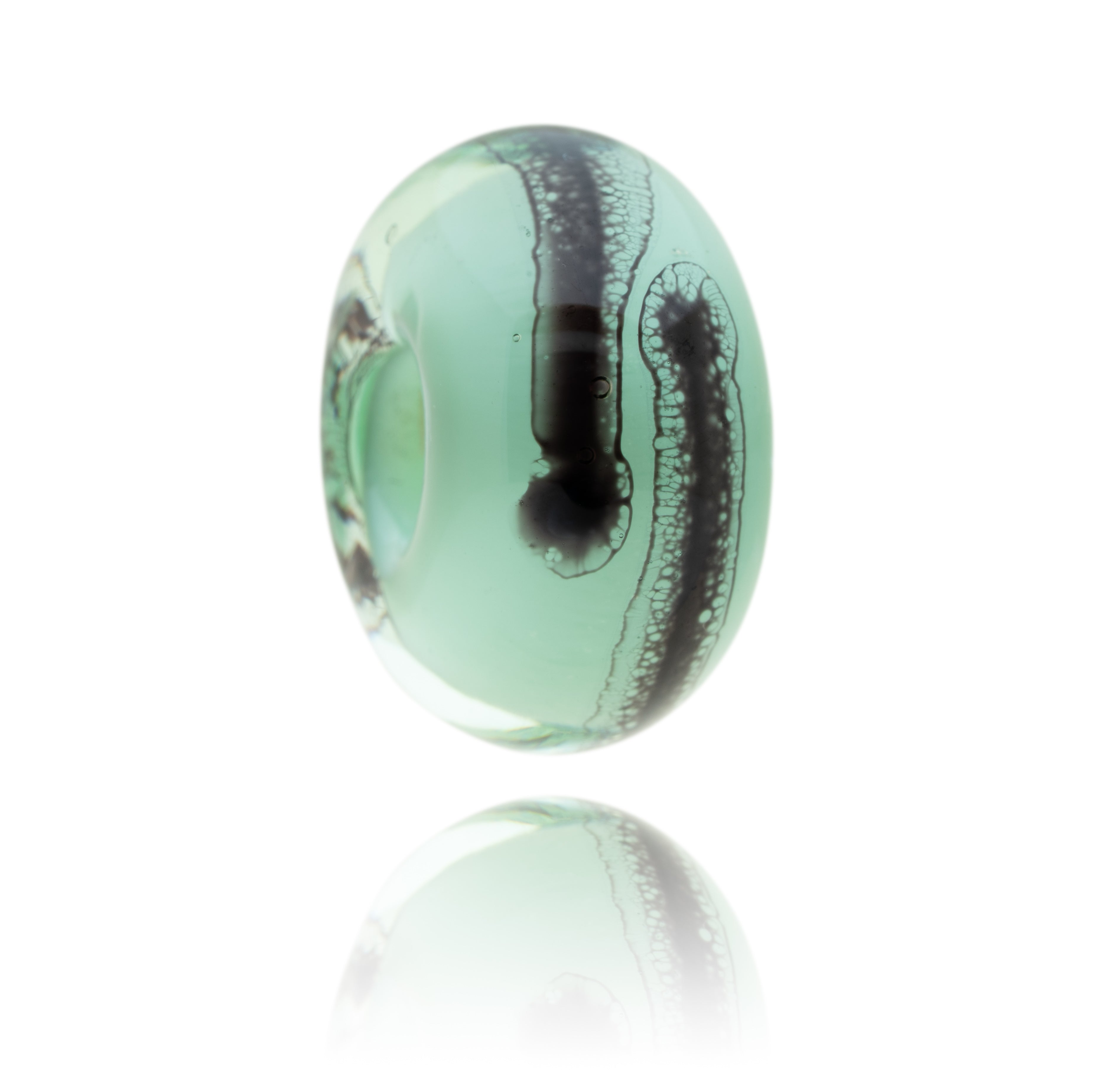 Green and clear glass bead with black webbed patterns on the surface representing Clevedon Pier in Somerset.