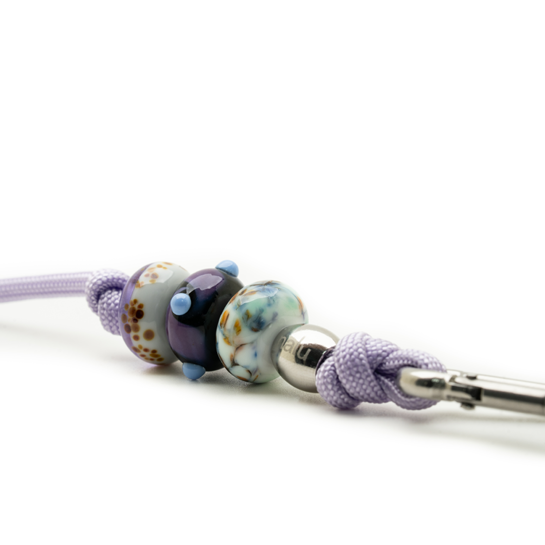 Close-up of a decorative cord with beads on a white background