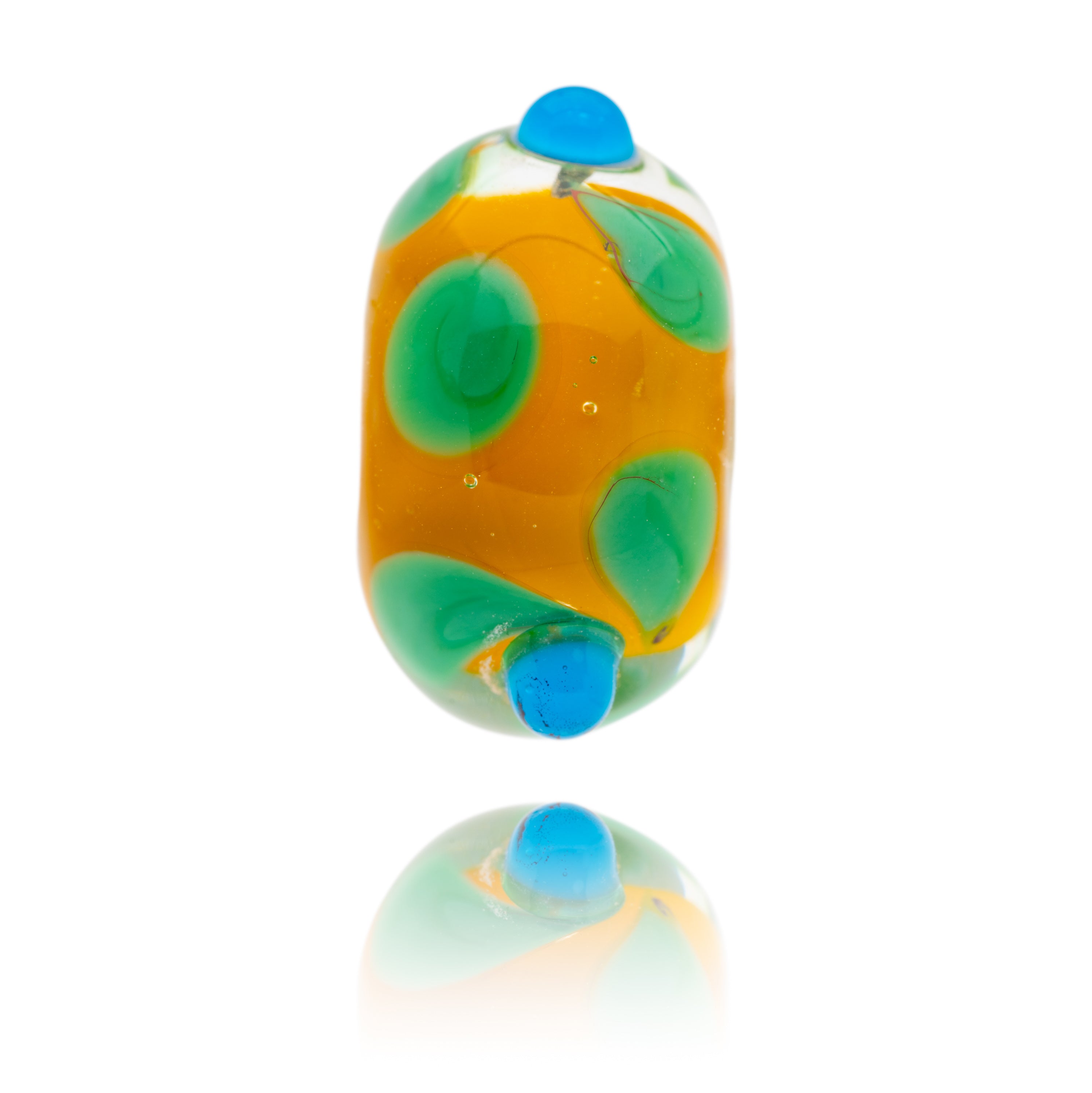 Gold glass bead with green and blue surface petal patterns, designed for the island of Cuba in the Caribbean.