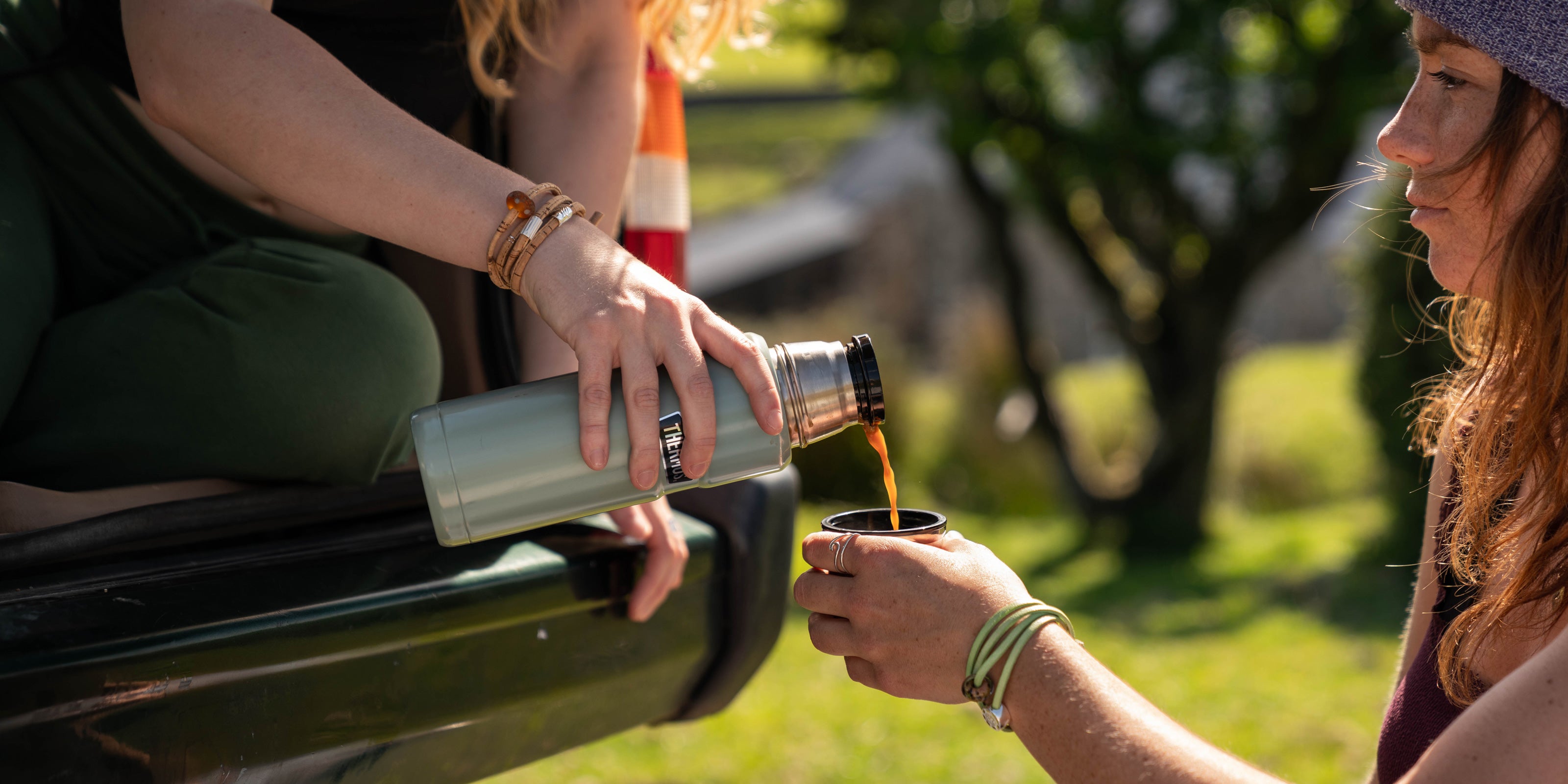 Girls camping out on Dartmoor with thermos flask wearing National Park Nalu Beads on cork wraps.