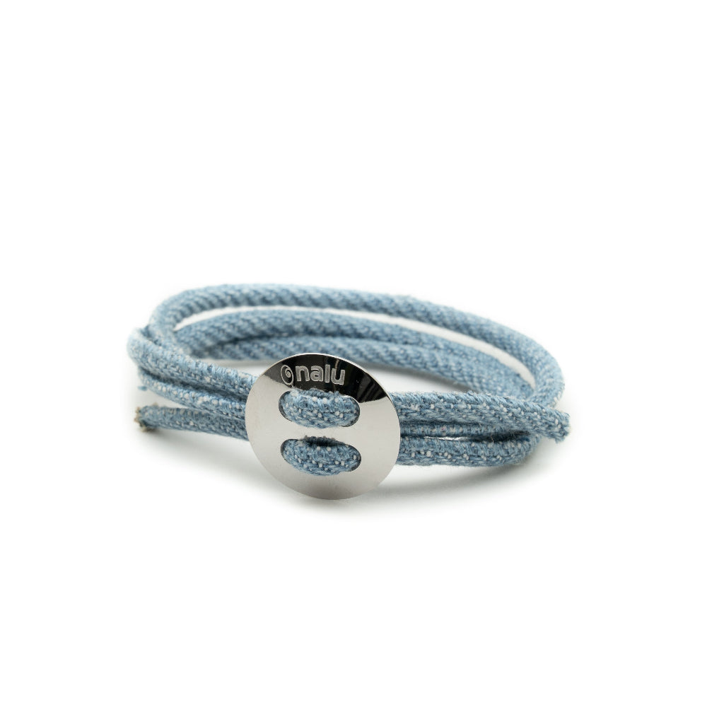 Light blue textured bracelet with a silver circular tag on a white background