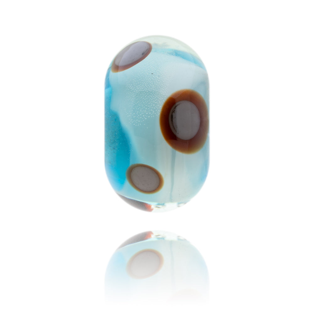 Turquoise glass bead with brown circular patterns on the surface representing Findhorn in Scotland.