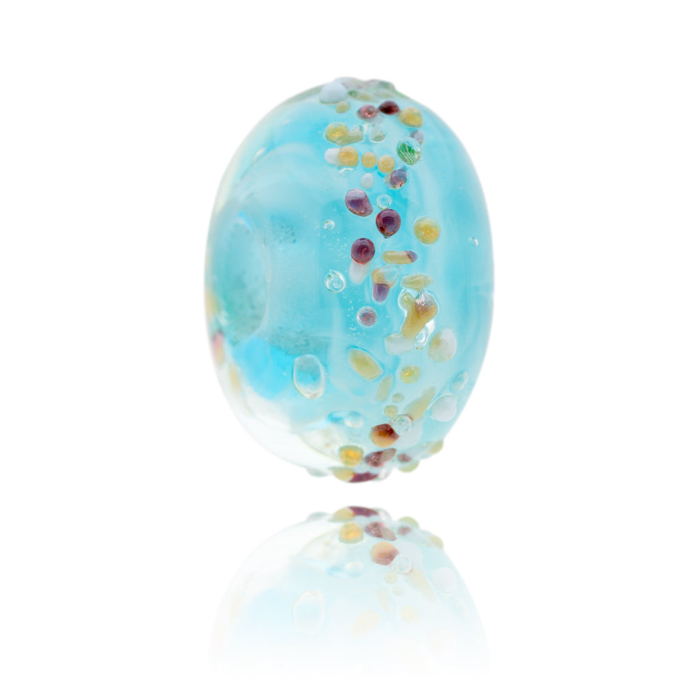 Turquoise glass bead with colourful dots on surface, representing the Isle of Harris in Scotland.