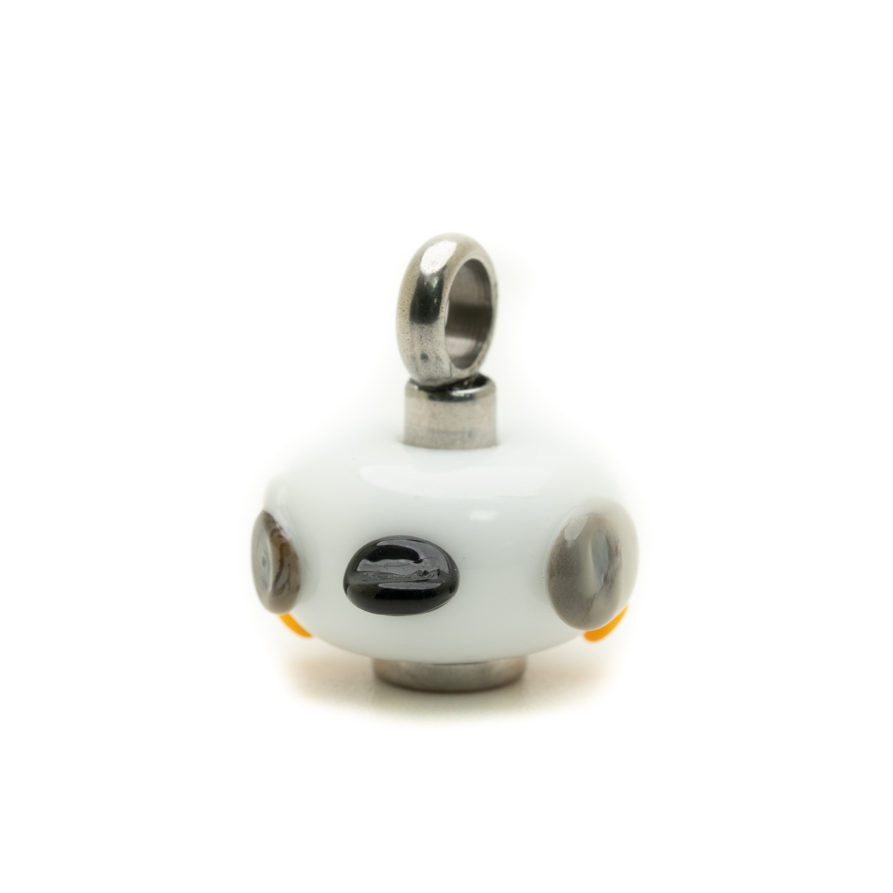A small white glass pendant charm with a silver metal bail at the top, featuring a black oval center and gray circular details on a white background.