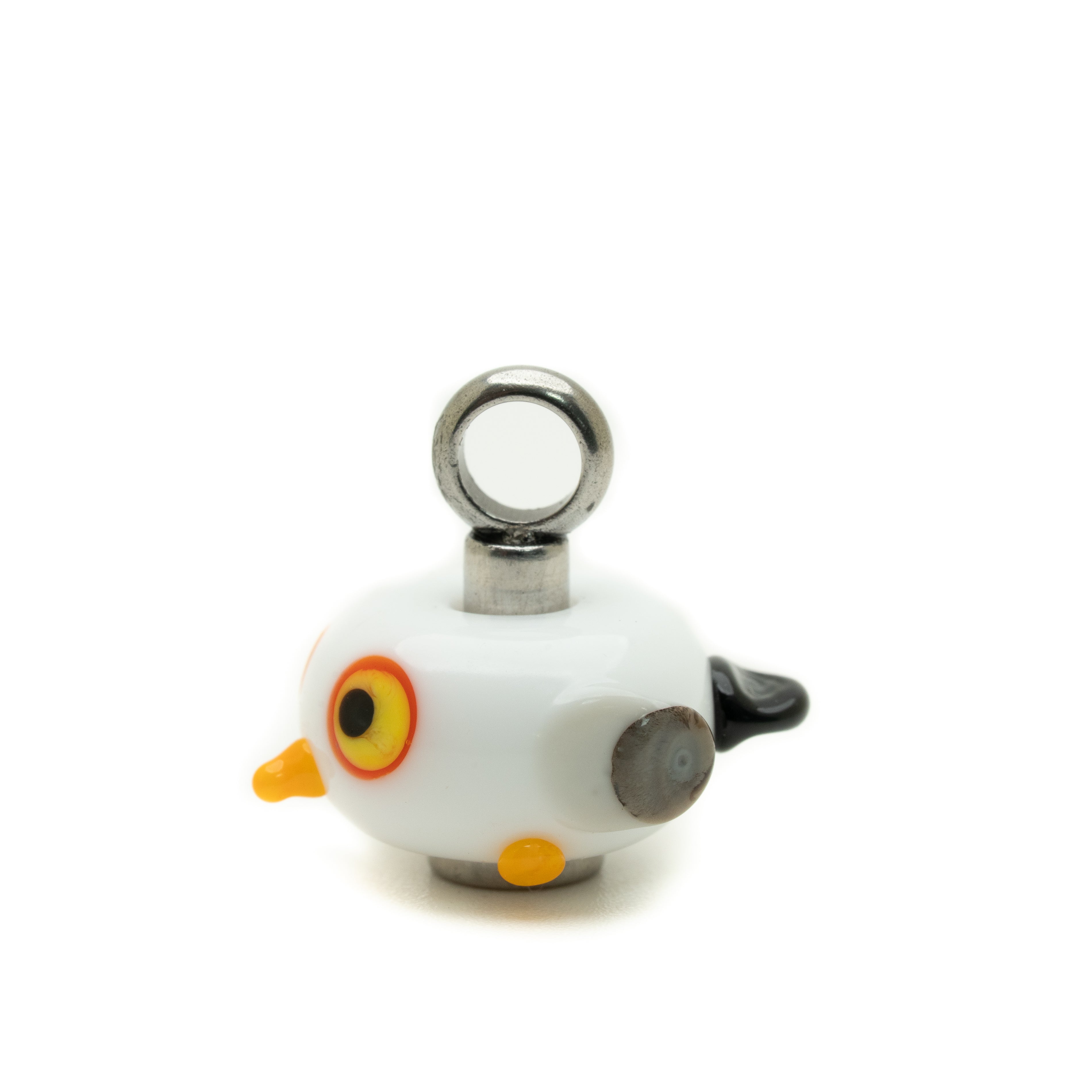 A small white bird-shaped keychain charm with a silver metal ring at the top, featuring a yellow beak, orange and yellow eye, gray wing, and black tail, set against a plain white background.