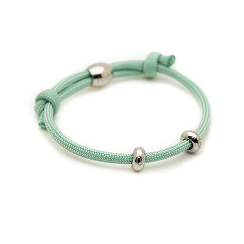 Mint green bracelet with silver beads on a white background