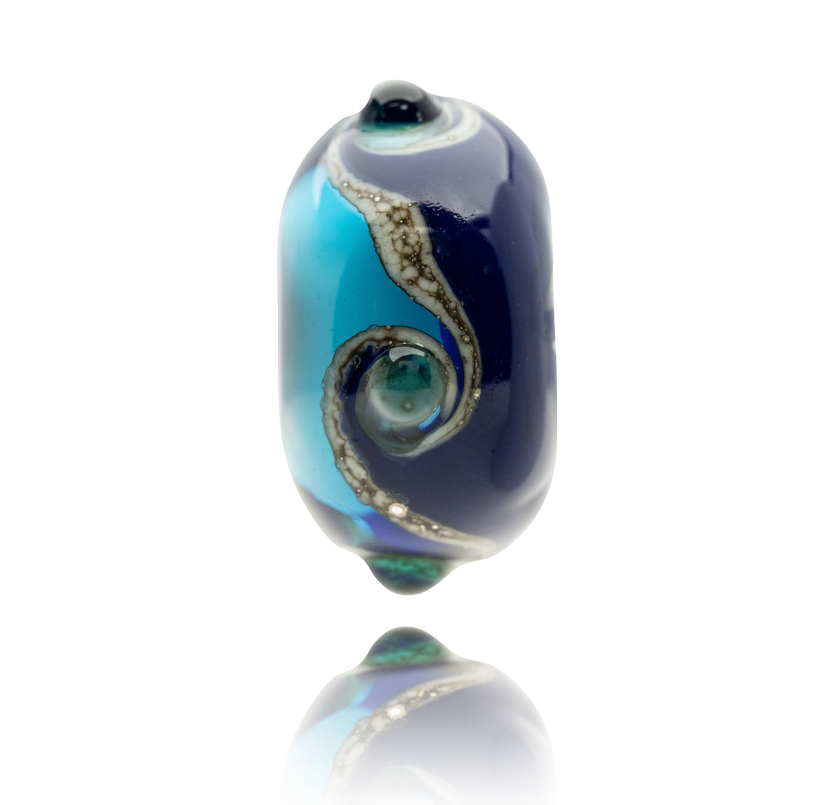 A single hand-blown glass lampwork bead with a dark navy blue and light blue swirl pattern, accented by metallic silver and green details, shown on a white background with a soft reflection below.