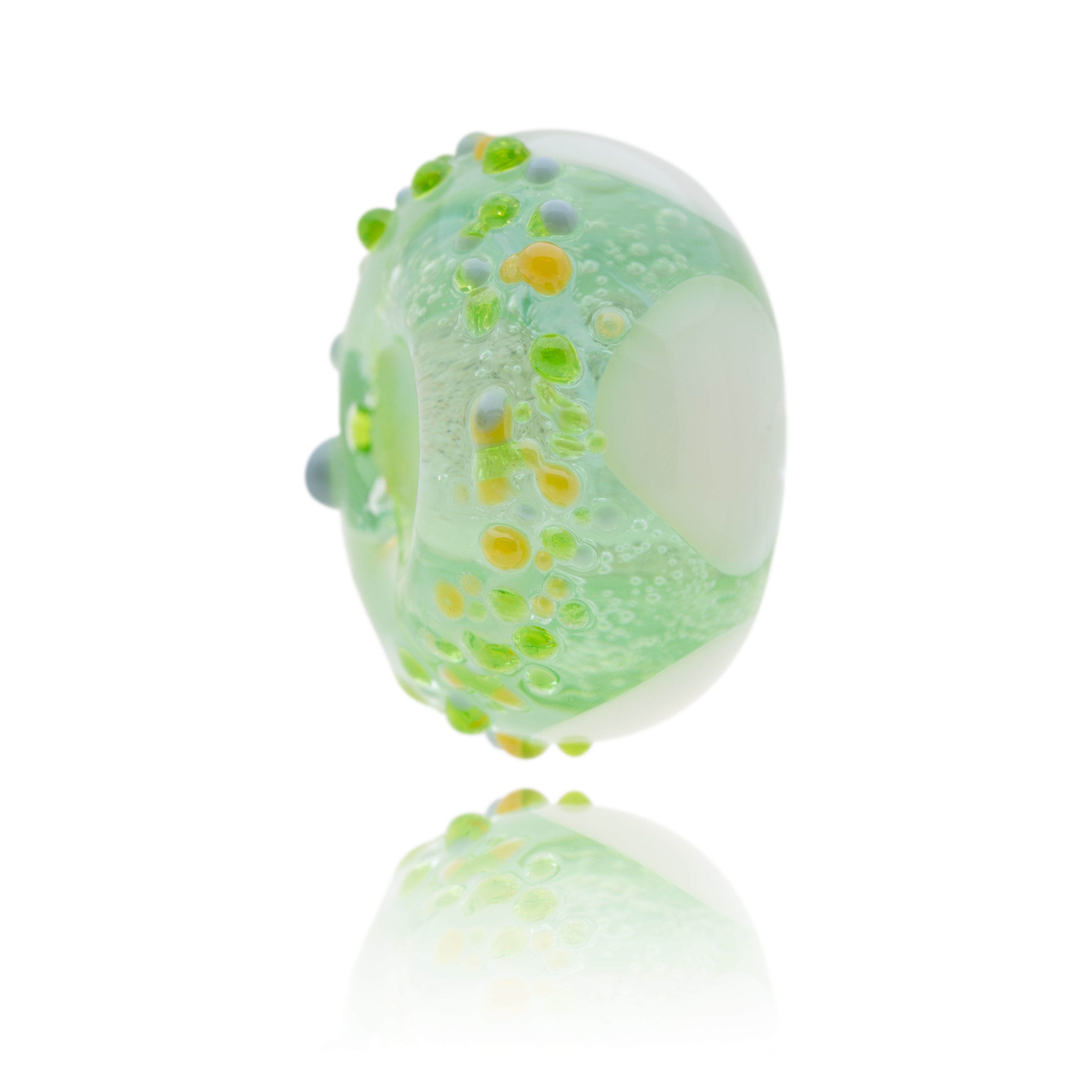 Green glass bead with white triangles and raised grey and amber spots on the other, representing Minehead in Somerset.