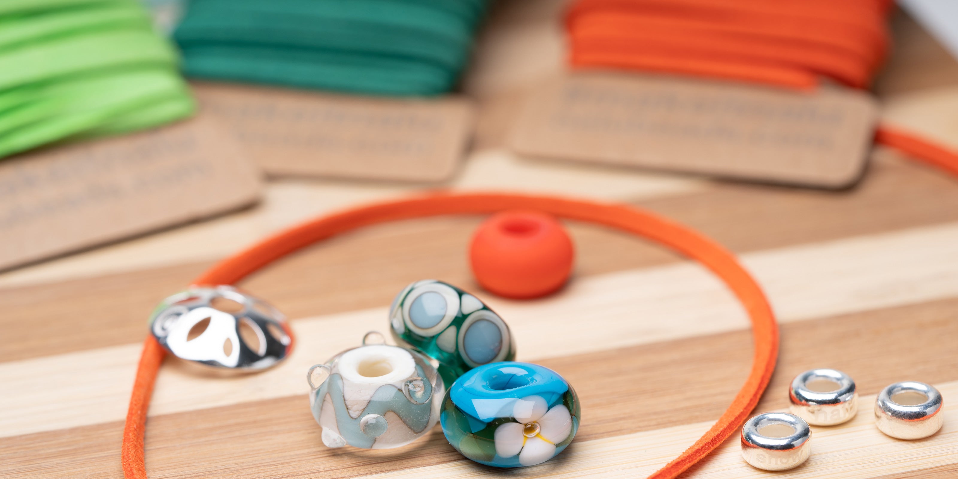 Bamboo braiding board with colourful vegan cords, silver and glass beads for making Nalu jewellery.