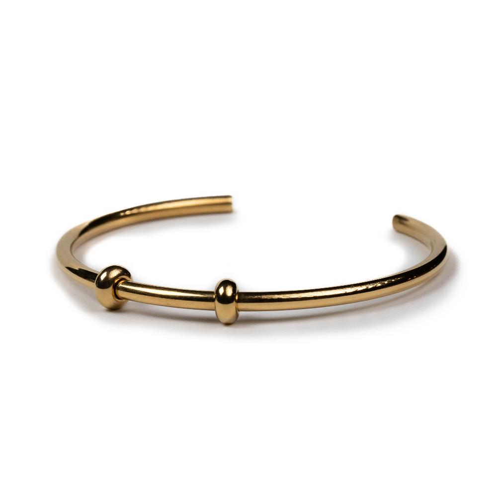 Gold bangle with stopper beads.