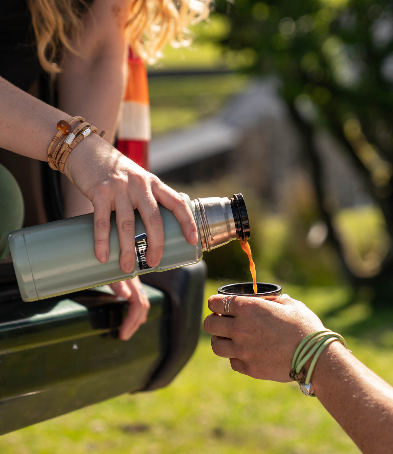 Girls camping out on Dartmoor with thermos flask wearing National Park Nalu Beads on cork wraps.