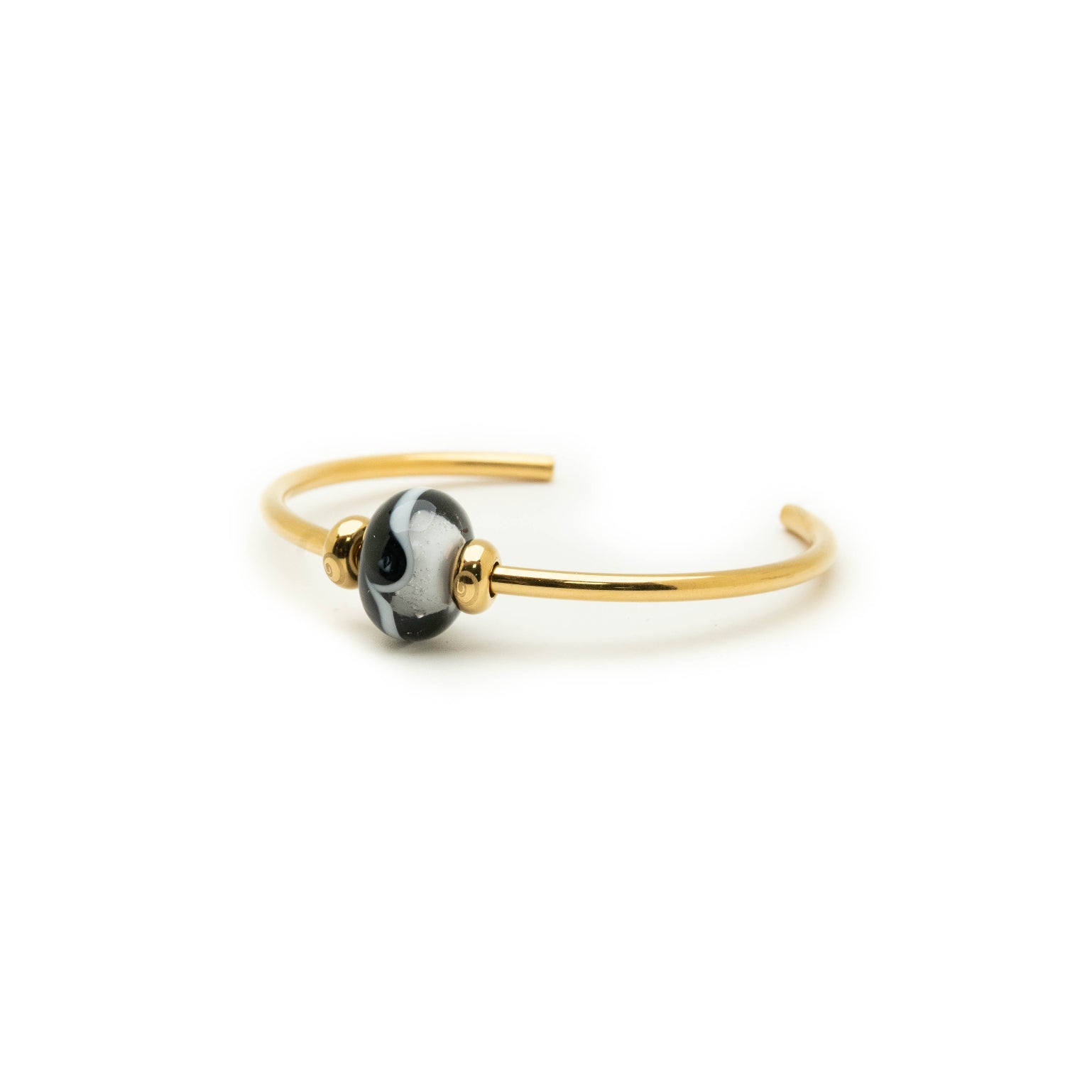Northumberland bead in black and white on gold bangle.