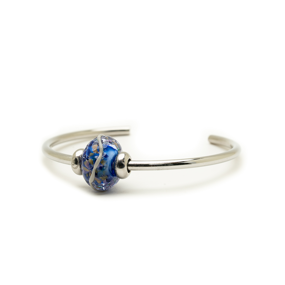 Silver bracelet with a blue and silver bead on a white background