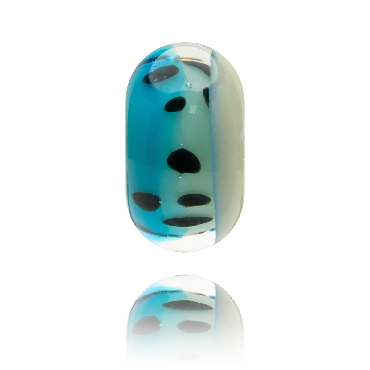 A single oval glass bead charm with a split design, featuring vibrant blue and translucent white sections with black spots, shown on a white background with a soft reflection below.