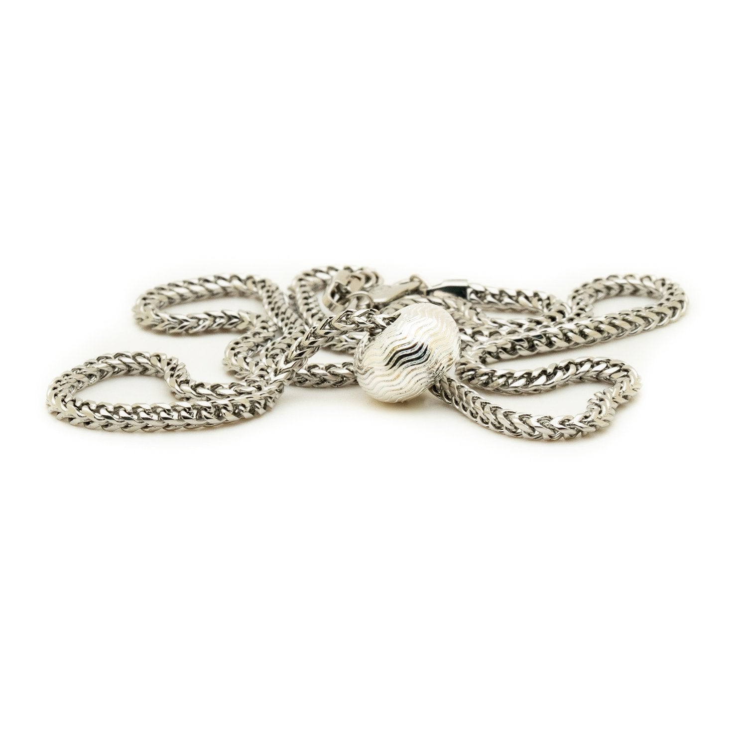 Silver steel necklace with silver oceans bead worn on it.