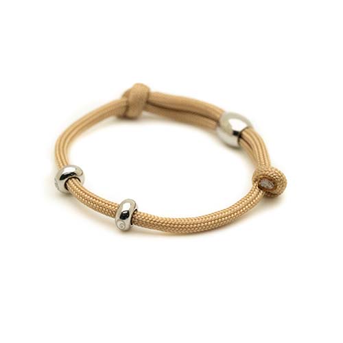 Beige bracelet with silver beads on a white background