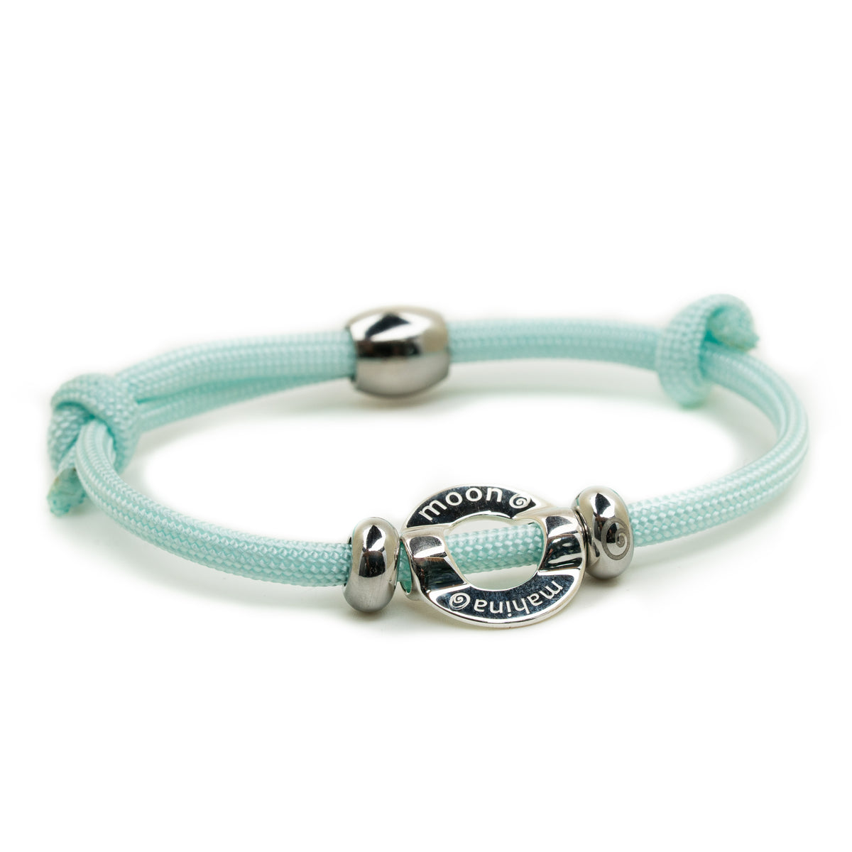 A mint green braided cord bracelet with a silver-toned sliding clasp and a central round charm engraved with 'moon'.