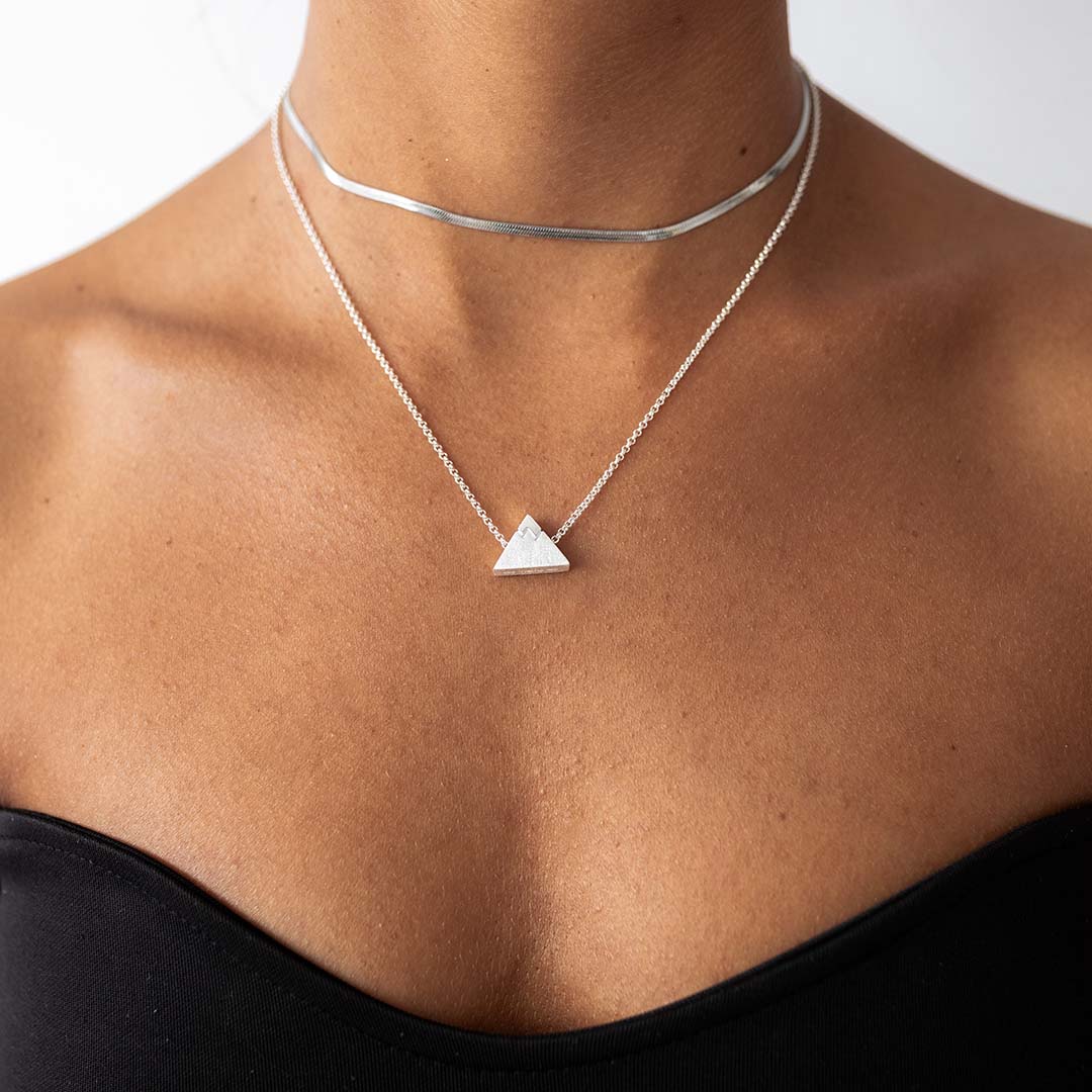 Woman wheaten a silver chain necklace with the silver peak bead and our silver shoreline necklace.