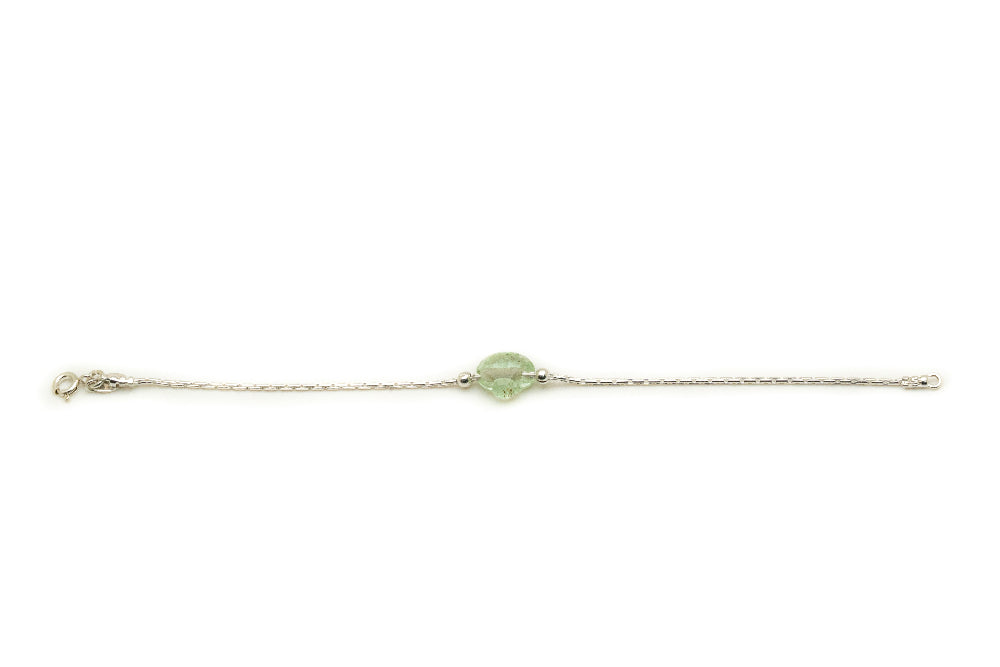 Silver bracelet with a green glass shell on a white background