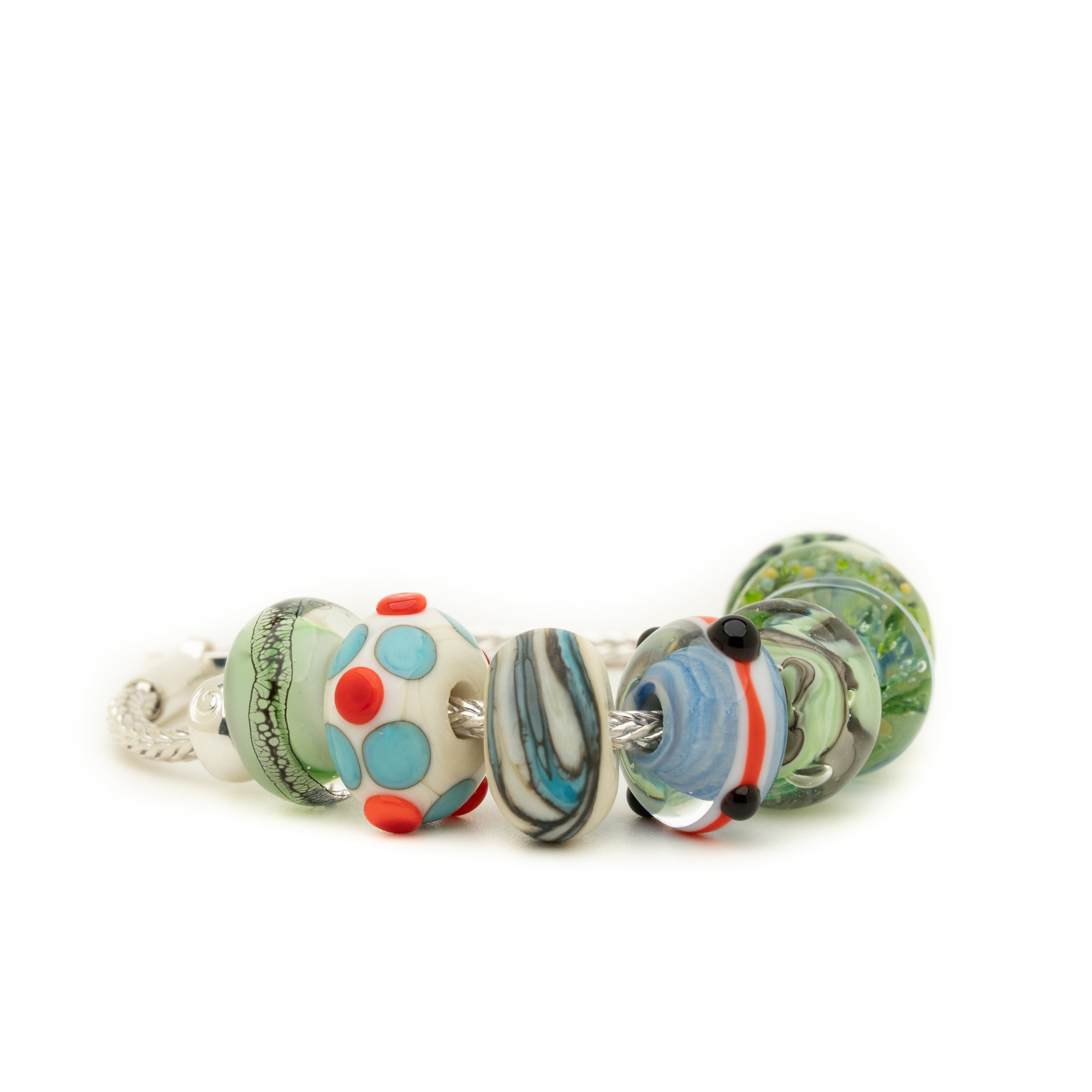 Silver bracelet with eight glass lamp work beads in shades of blues, greys and green with some red.