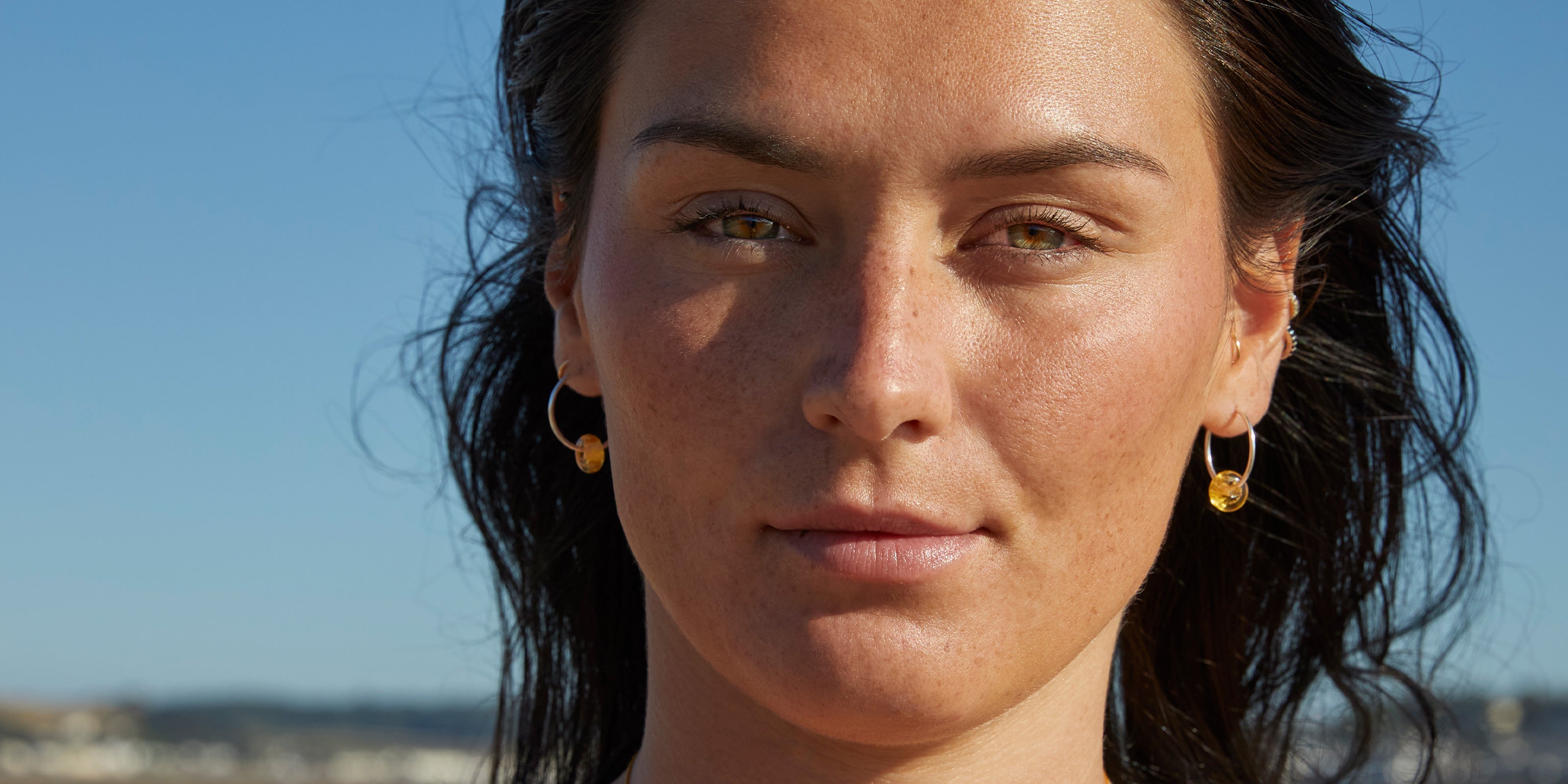 Girl wearing amber glass beads on sterling silver hoop earrings at the beach Crow Point.