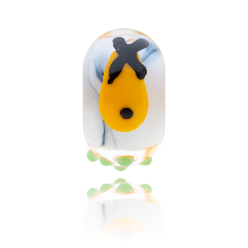 Black and white glass bead with a decoration of fish, chips and peas on the surface.