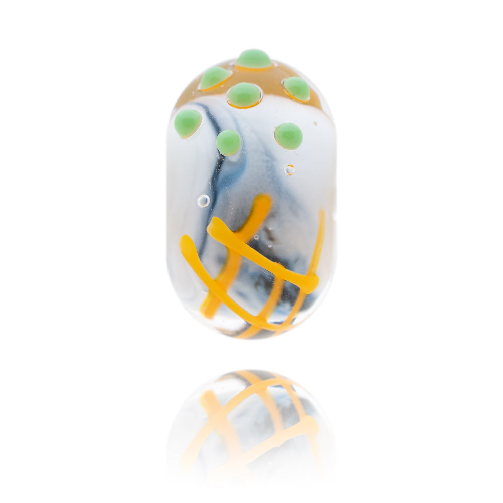 Black and white glass bead with a decoration of fish, chips and peas on the surface.