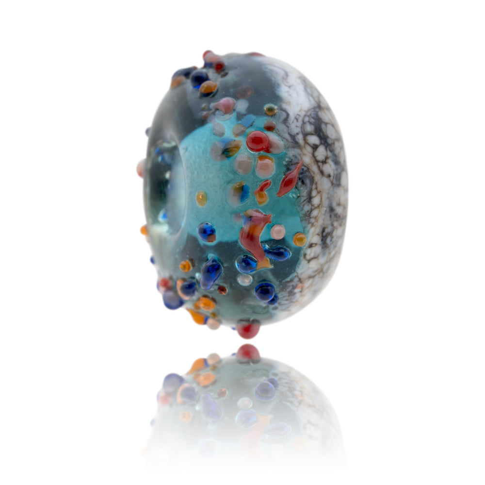 Blue and brown glass bead with colourful glass dots on the surface representing Tobermory in Scotland.