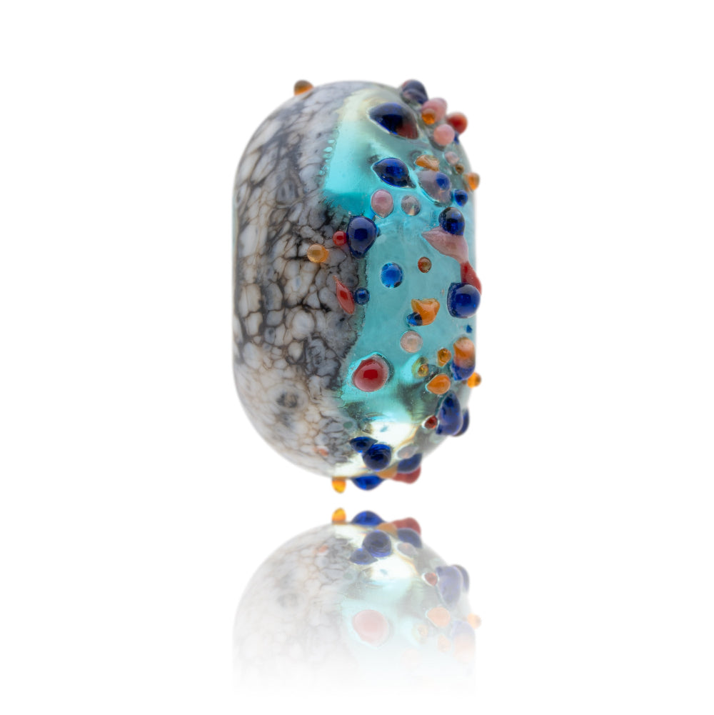 Blue and brown glass bead with colourful glass dots on the surface representing Tobermory in Scotland.