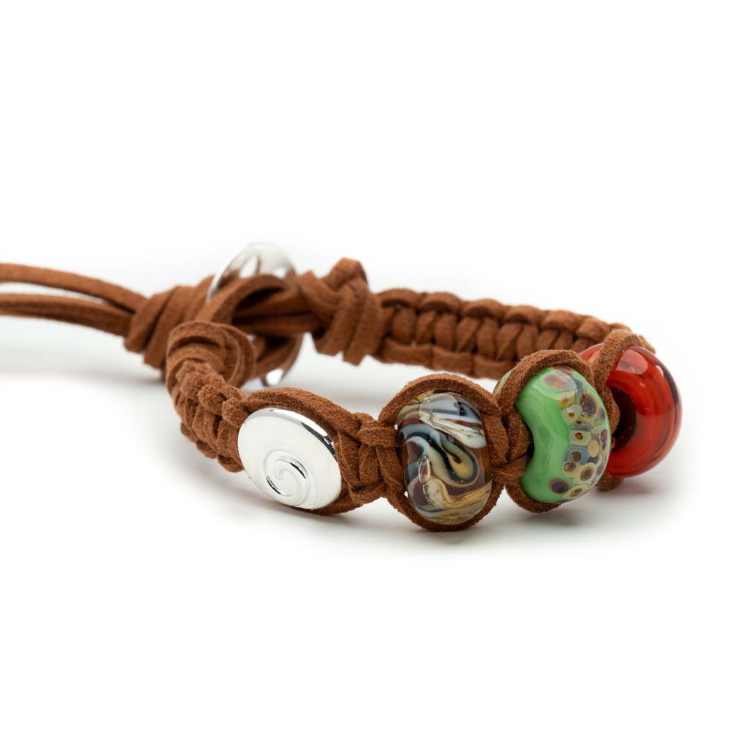 Brown cord macrame bracelet with green, red and brown glass beads and a silver swirl bead.