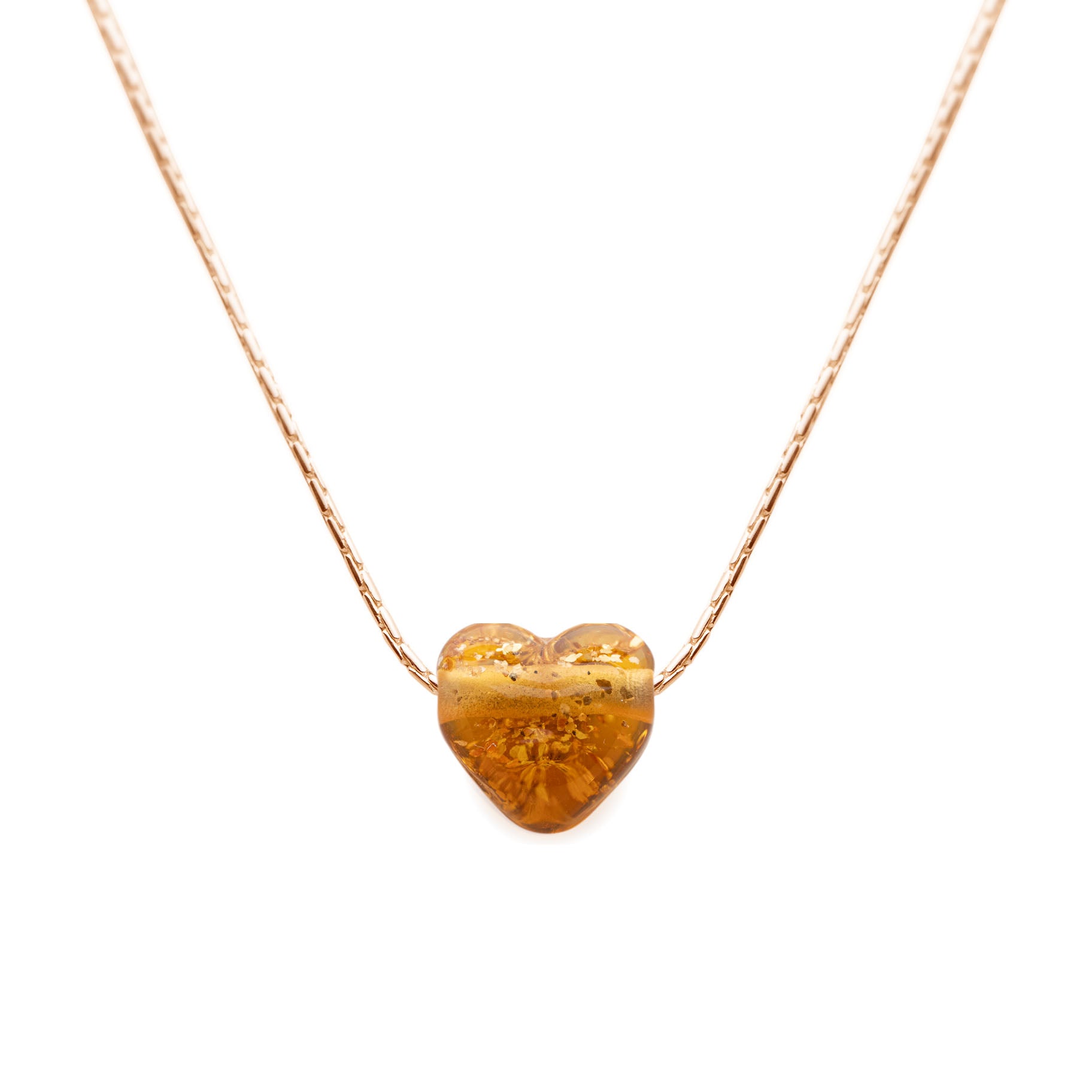 Heart-shaped amber pendant on a gold chain against a white background