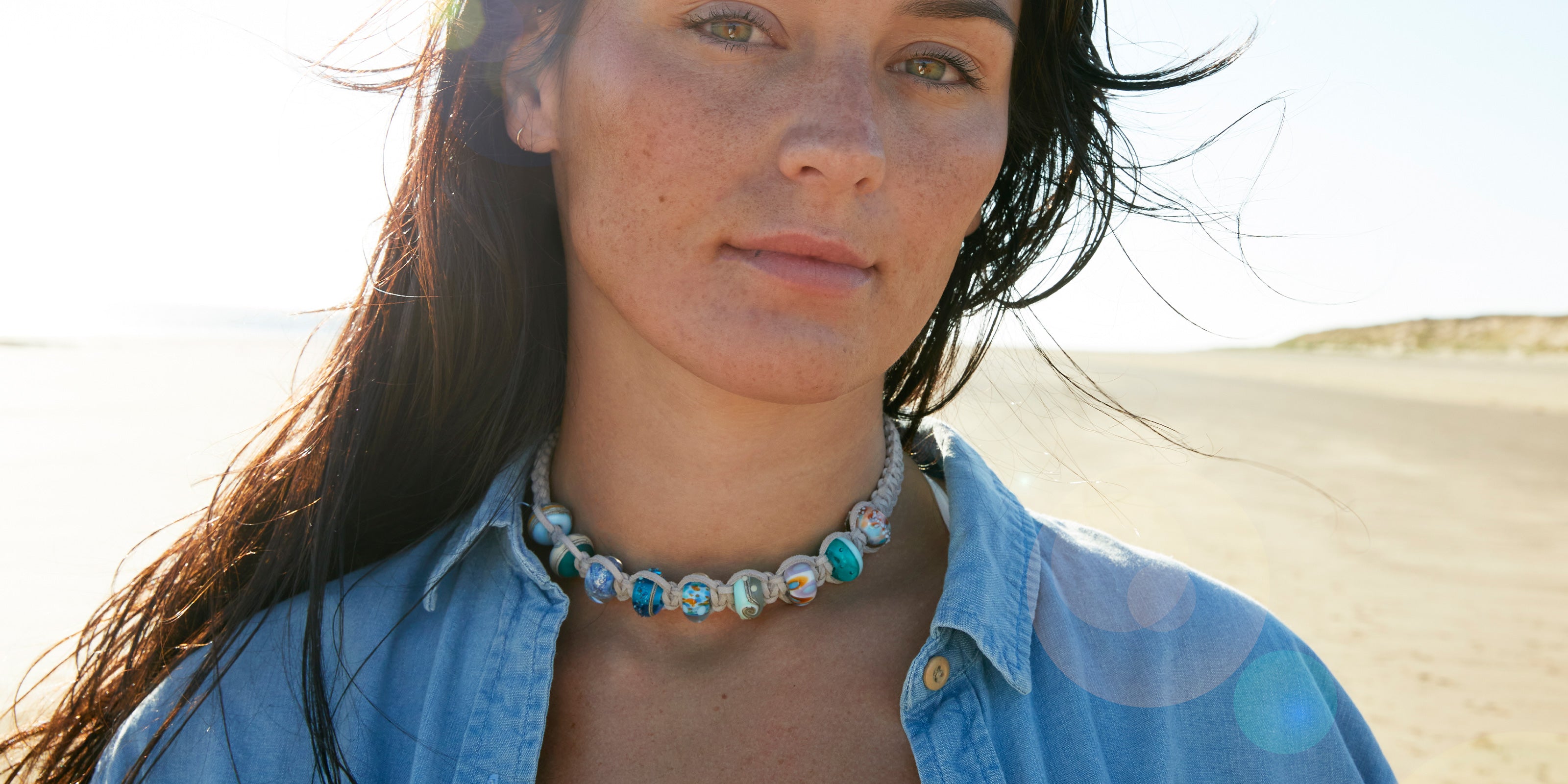 Colourful glass bead choker necklace worn by girl on the beach.