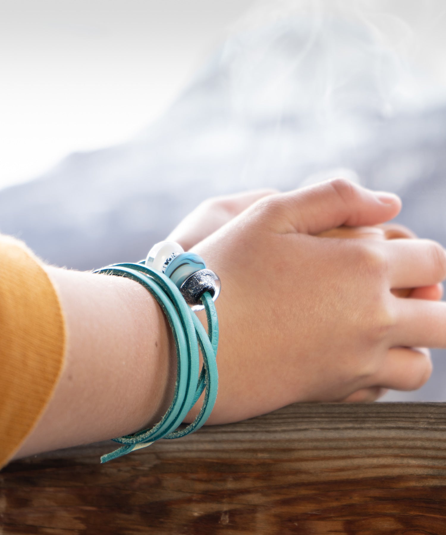 French snow glass beads on turquoise leather wrap bracelet worn by skier.