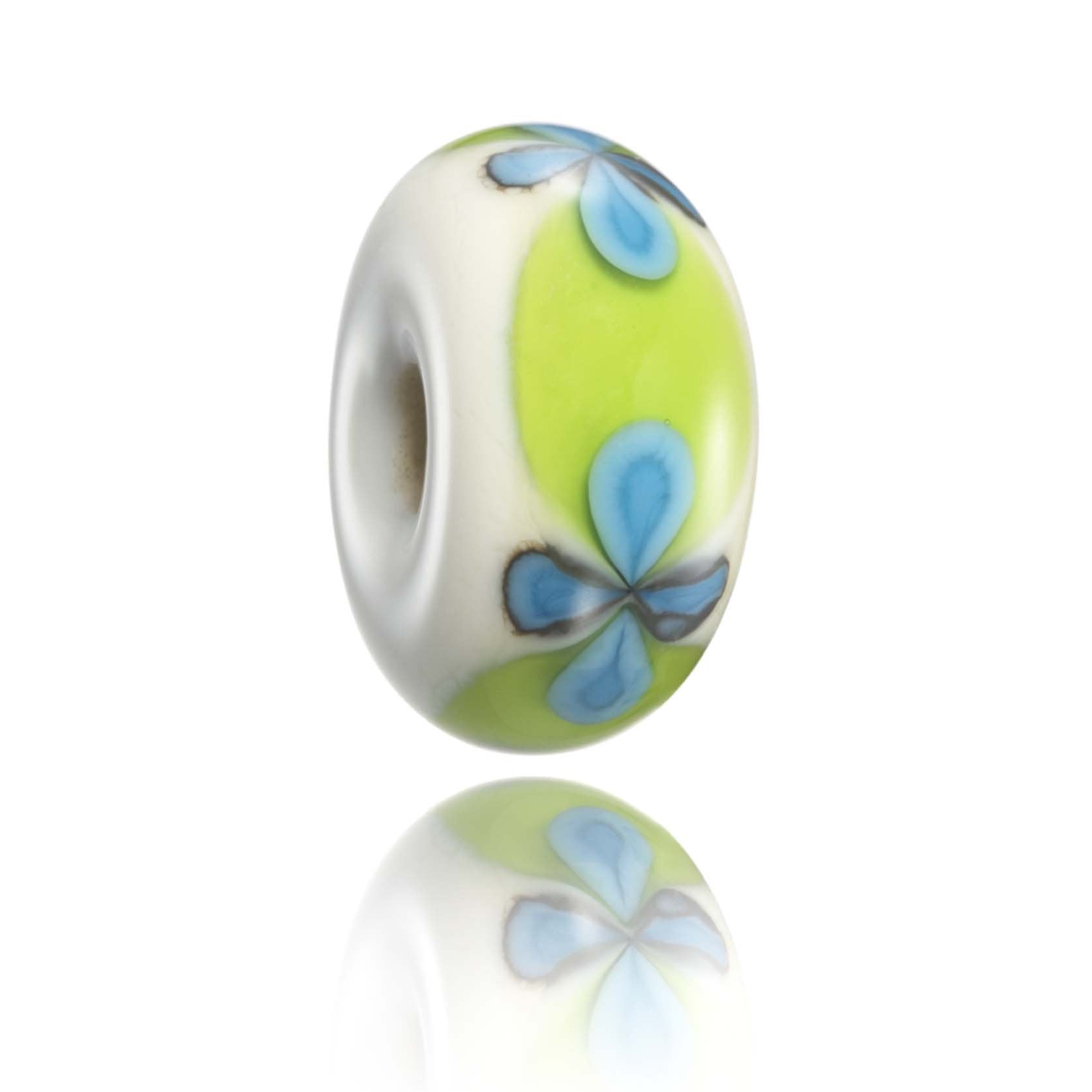 Cream bead with green band and blue flowers on surface.