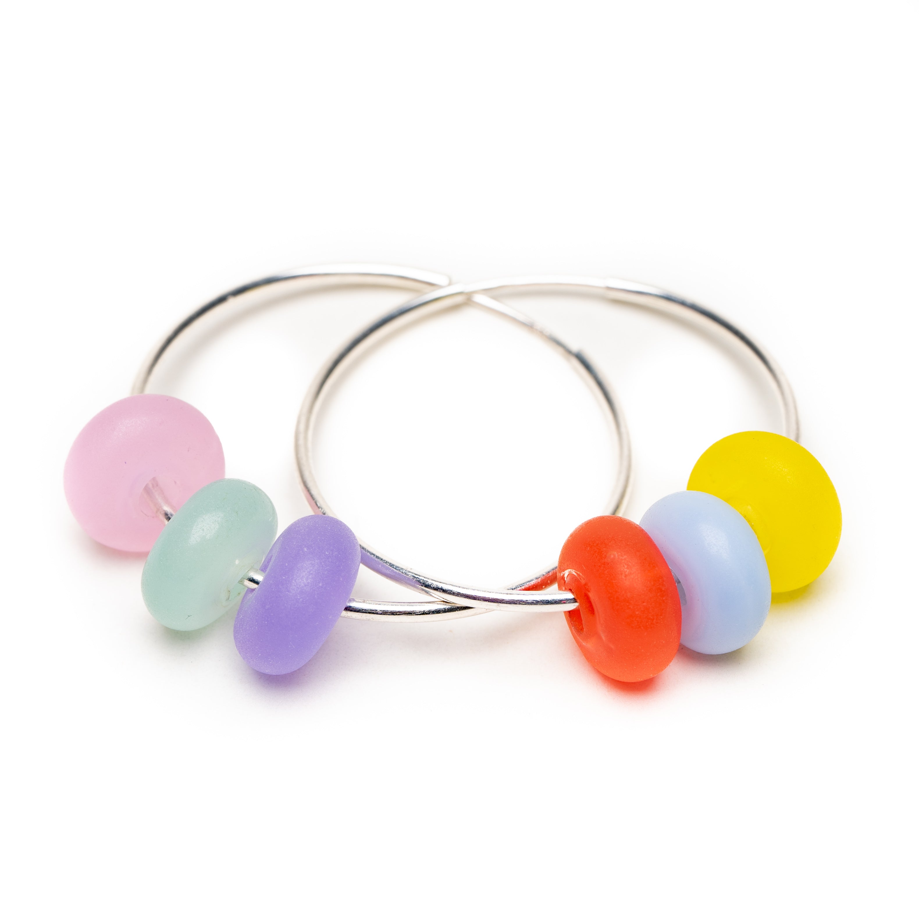 Teal, pink, purple, yellow, orange, blue small glass beads on silver hoop earrings.