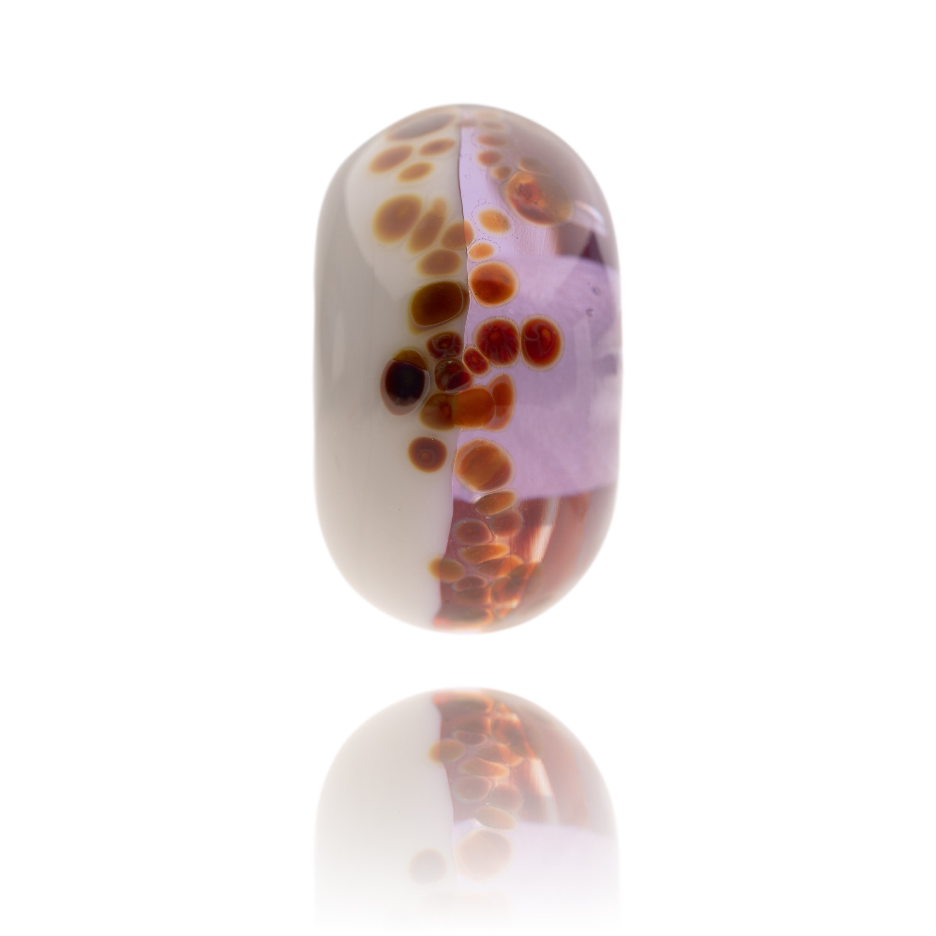Purple and white glass bead with brown spots o the surface for Crackington Haven in Cornwall.