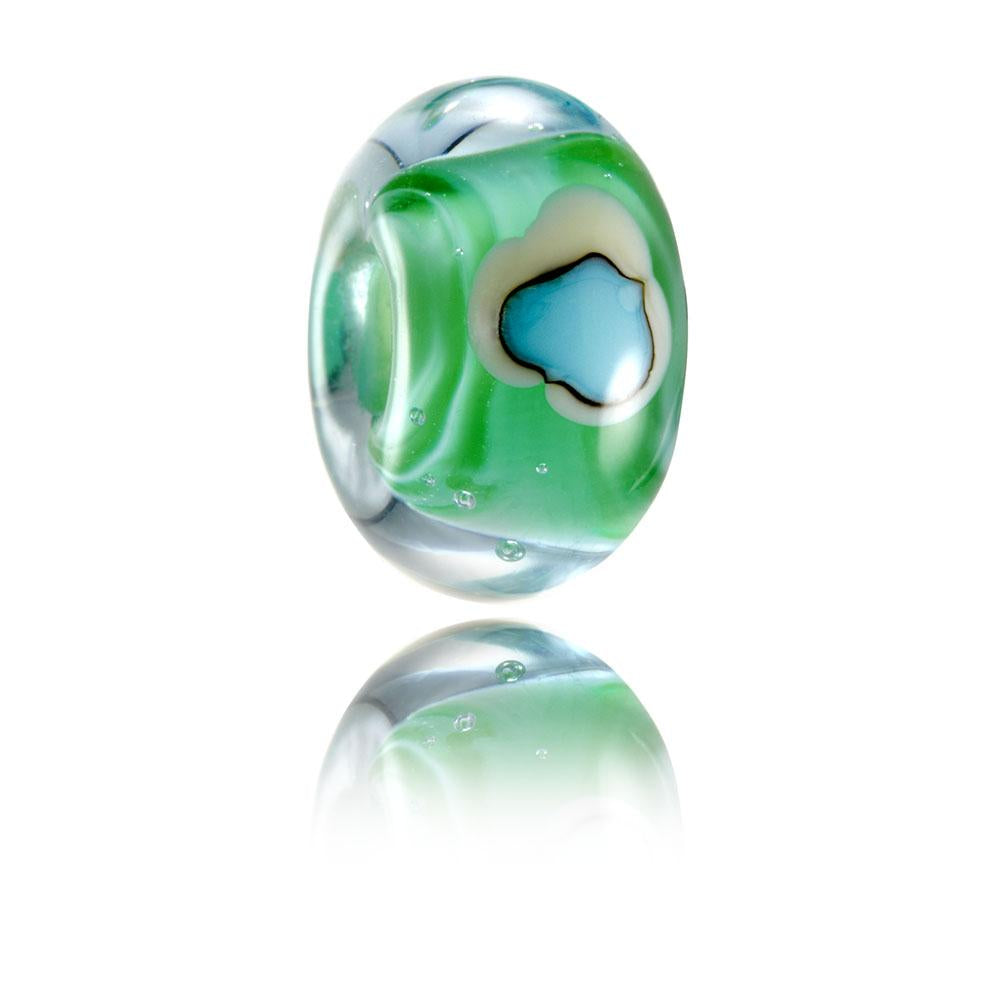 Green swirling glass bead with surface pattern of lighthouse island representing Godrevy in Cornwall.
