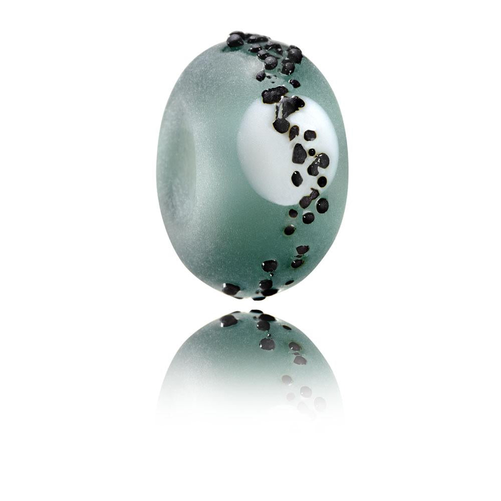 Grey frosted glass bead with white dot and black shards on surface representing Hartland Point in North Devon