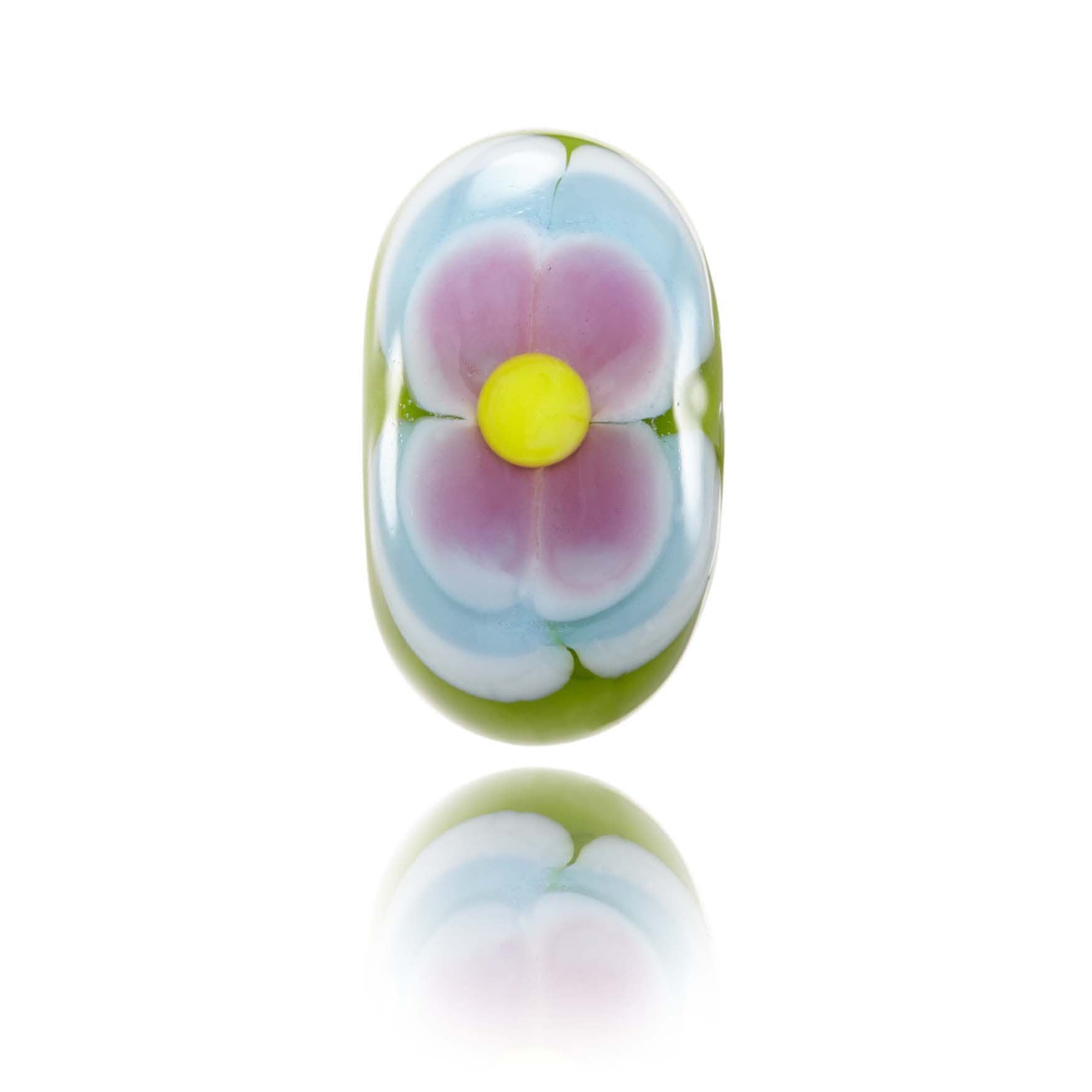 Green glass bead with a blue and pink flower pattern on the surface. Representing Oahu Island in Hawaii.