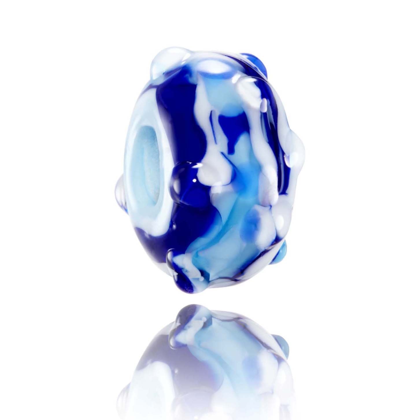 Swirling blue and white glass bead with clear raised dots on the surface, representing Porthcothan in Cornwall.