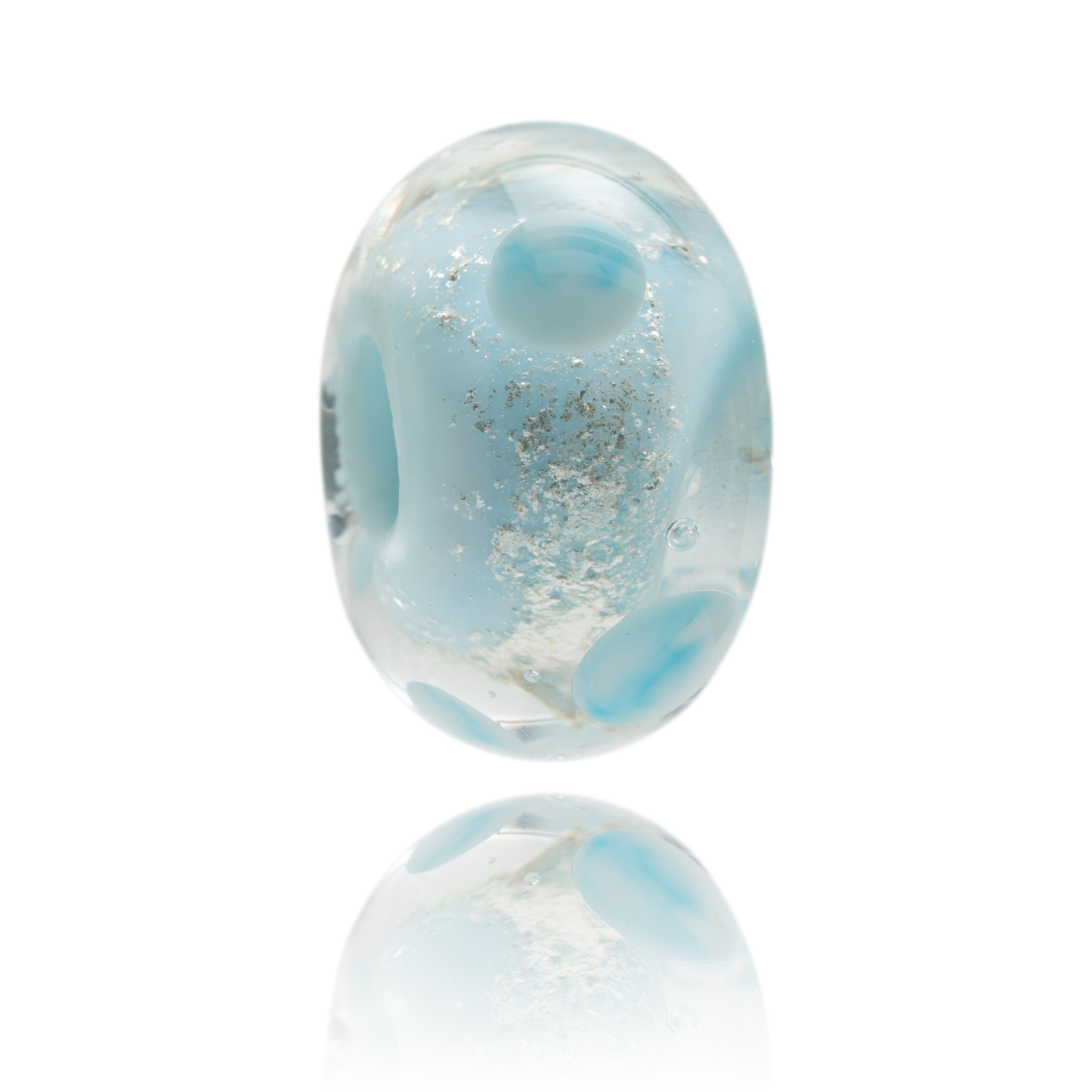 Light blue sparkly bead decorated with clear glass and dots. This glass bead represents Anglesey in Wales.