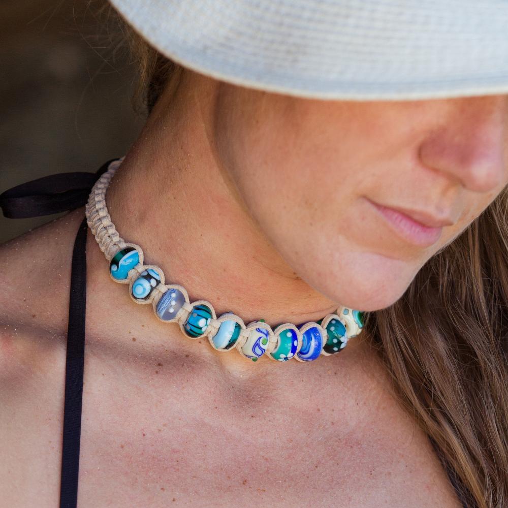 Woman wearing Nalu beaded custom necklace with colorful travel charms.