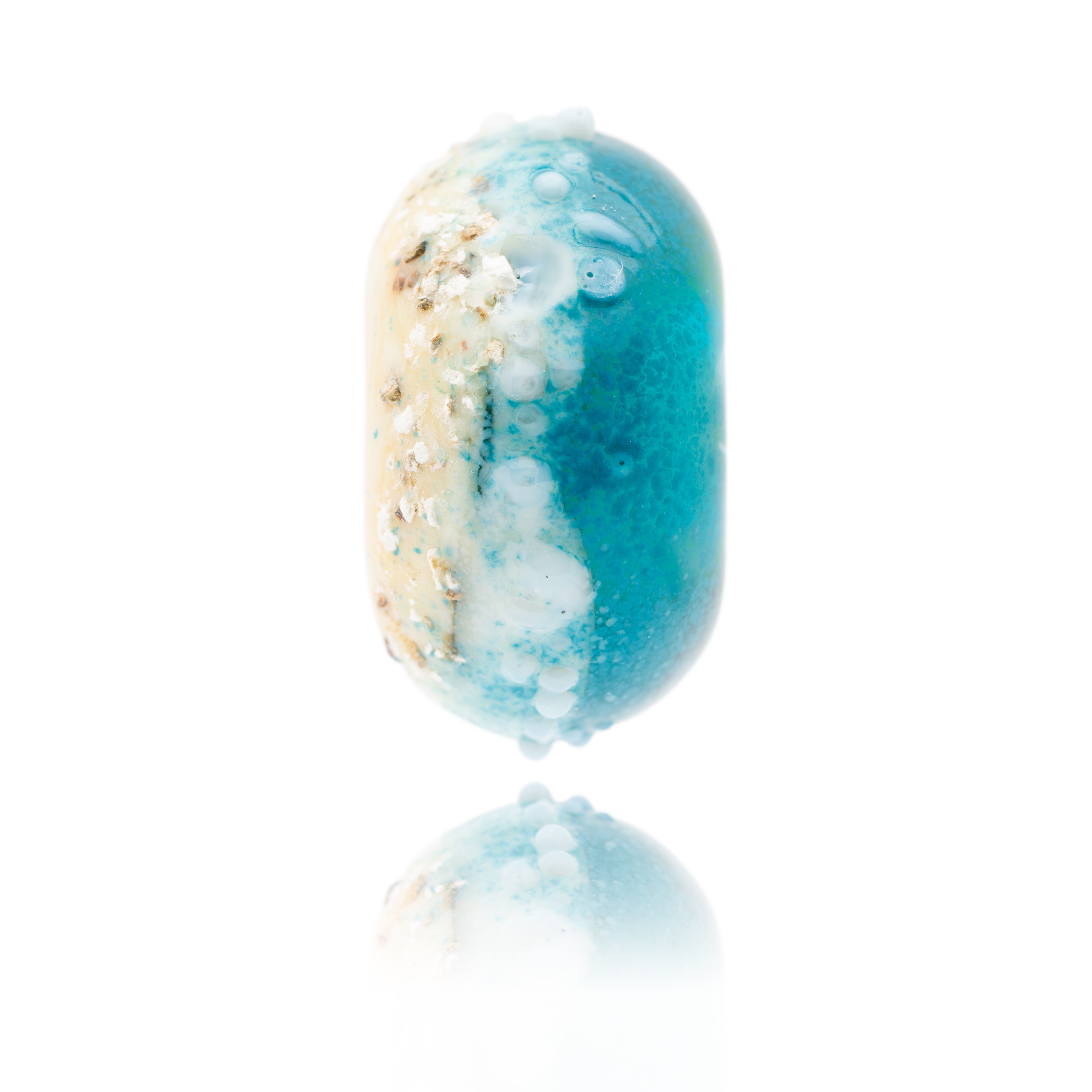 Glass bead in cream and blue with surface sand texture from Fistral beach inspired by Fistral shoreline painting by Gemma Lessinger Art in Cornwall.