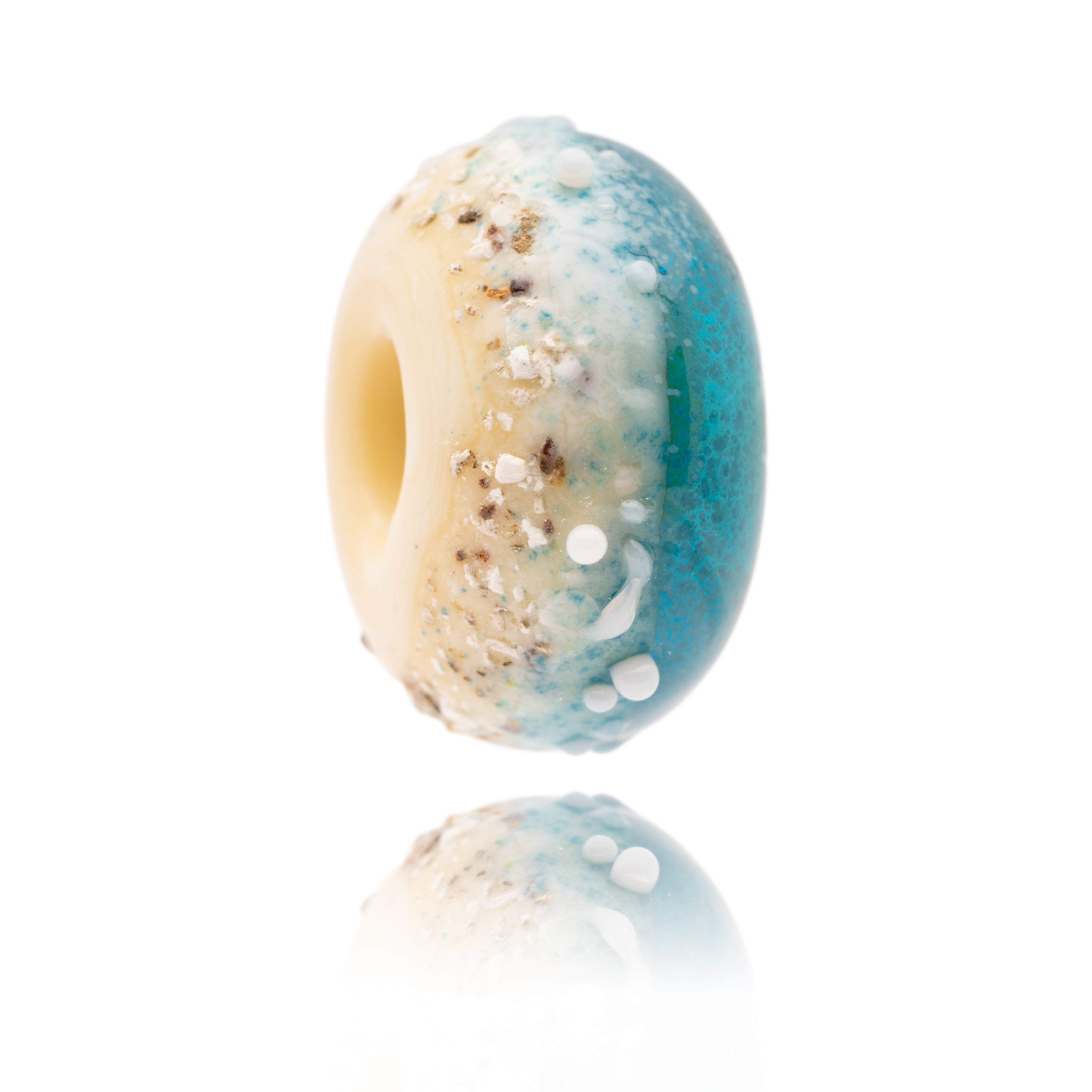 Glass bead in cream and blue with surface sand texture from Fistral beach inspired by Fistral shoreline painting by Gemma Lessinger Art in Cornwall.